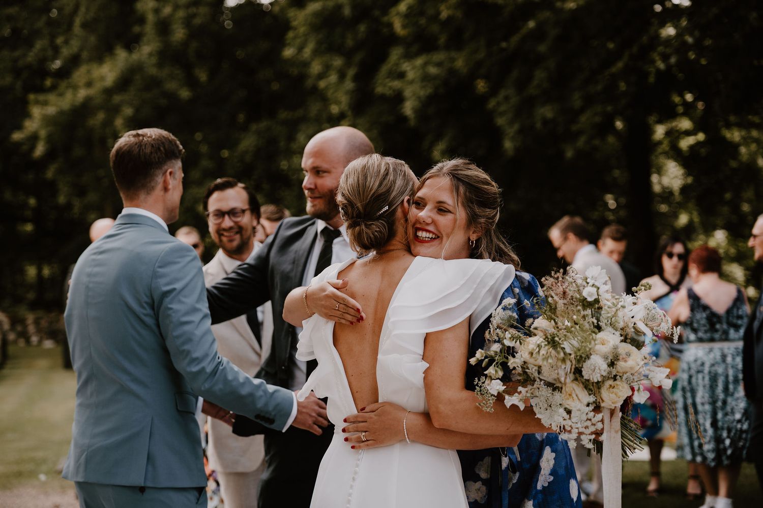 Joyful wedding ceremony taking place outdoors with guests gathered around celebrating the special moment.