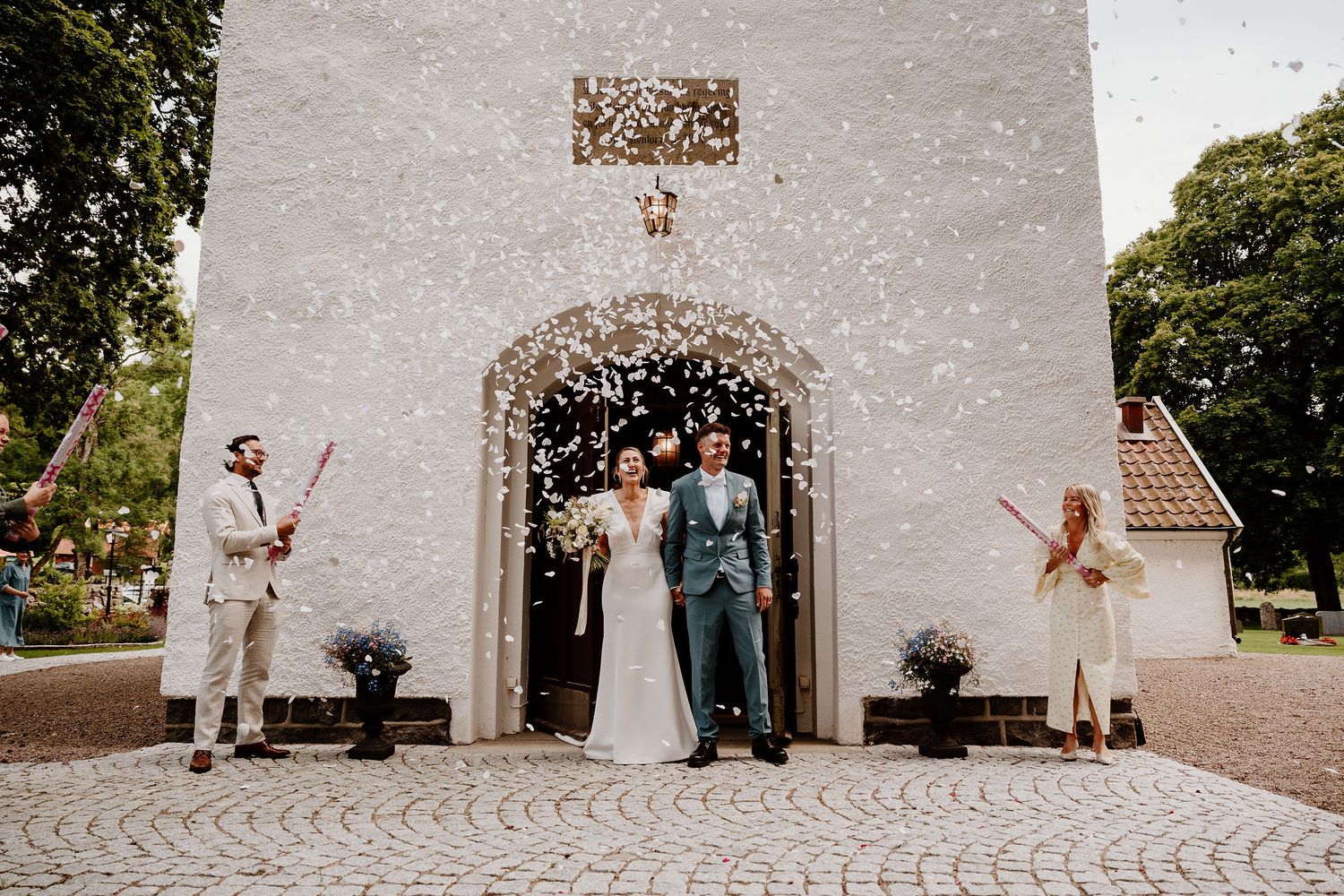 A panoramic sequence showing newlyweds dancing and celebrating on cobblestone in front of a rustic white church wall.
