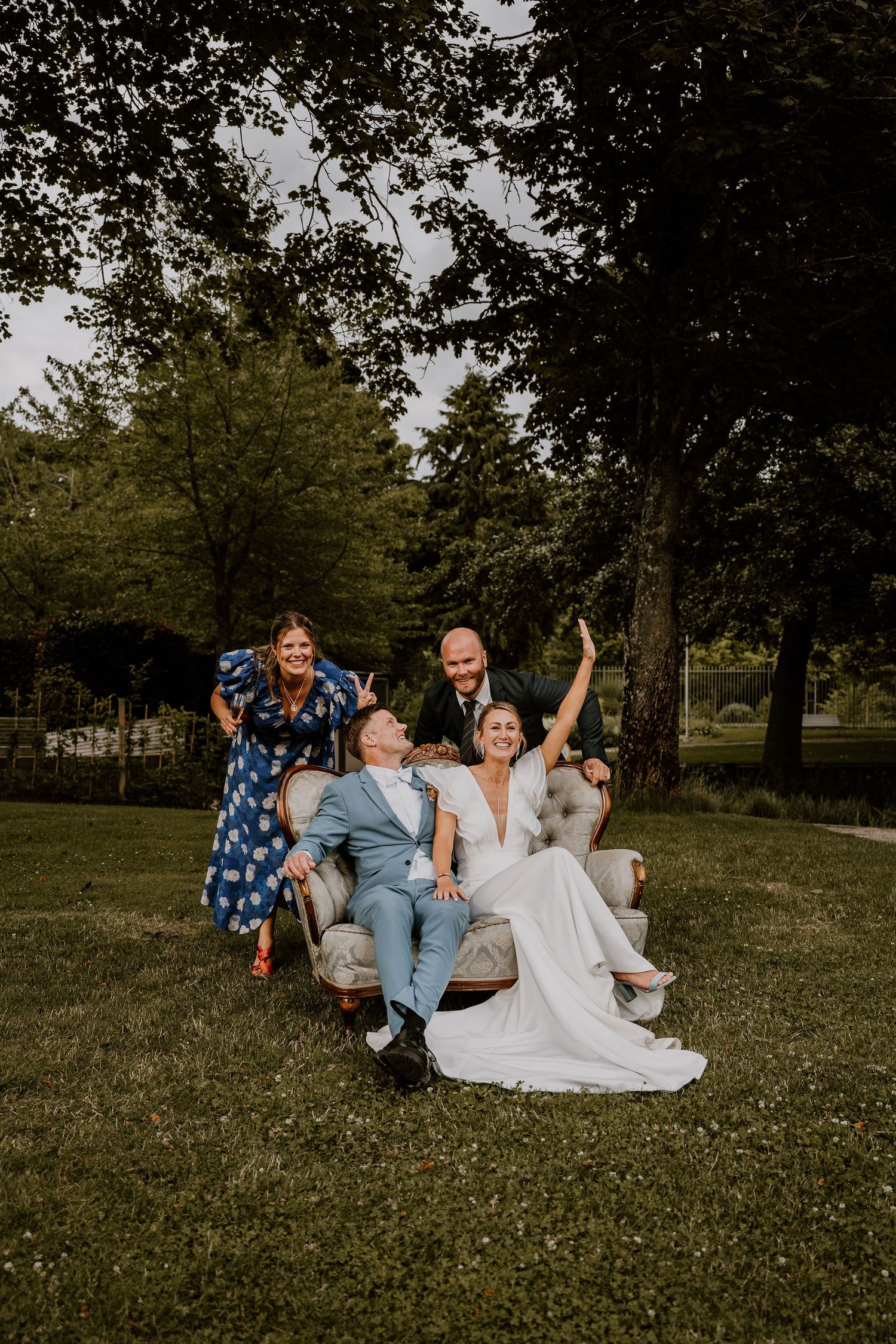 A group relaxes together on a grassy hill in a park setting during a casual outdoor photoshoot.