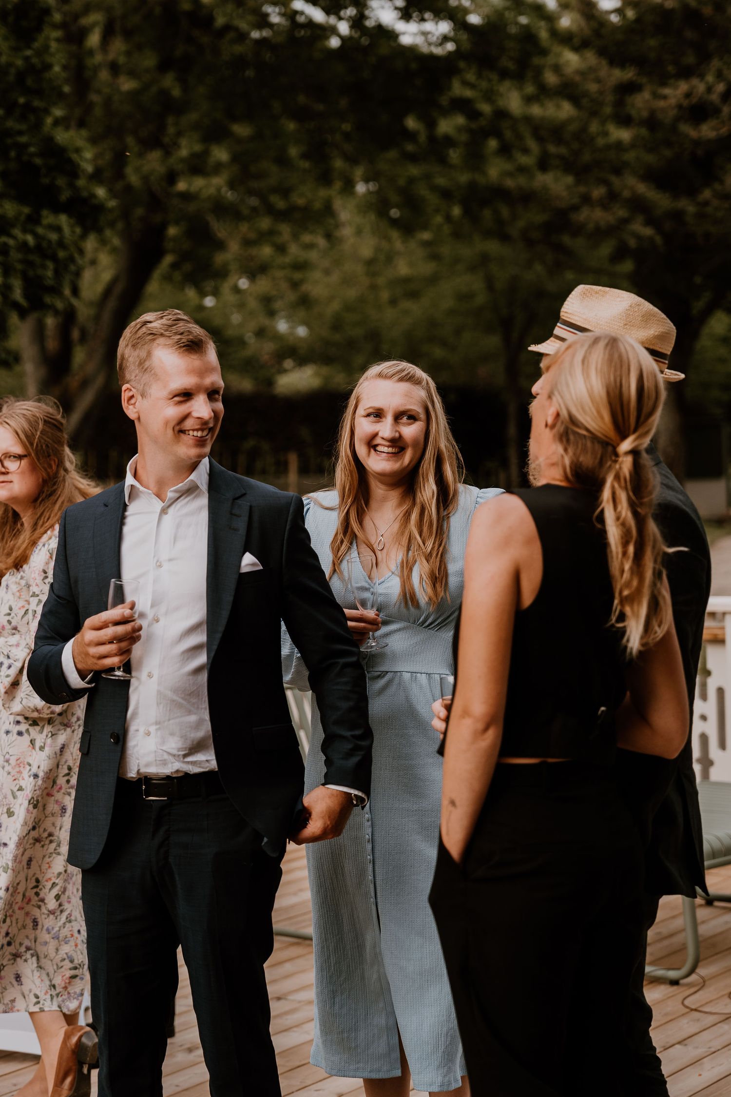 A joyful candid moment shared between wedding guests and bridal party members outdoors at sunset.