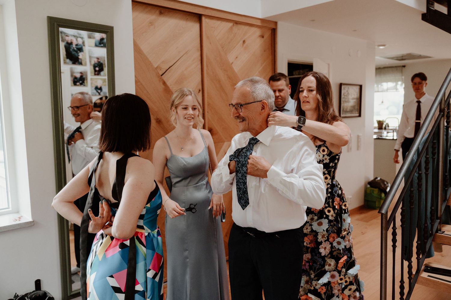 A small group of people gathered in a hallway wearing formal attire at what appears to be a special event.