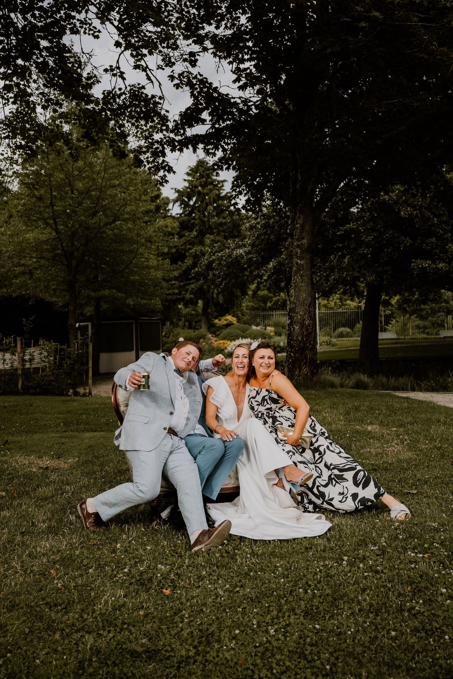 A group sits together on grass in an outdoor garden setting during a special celebration.