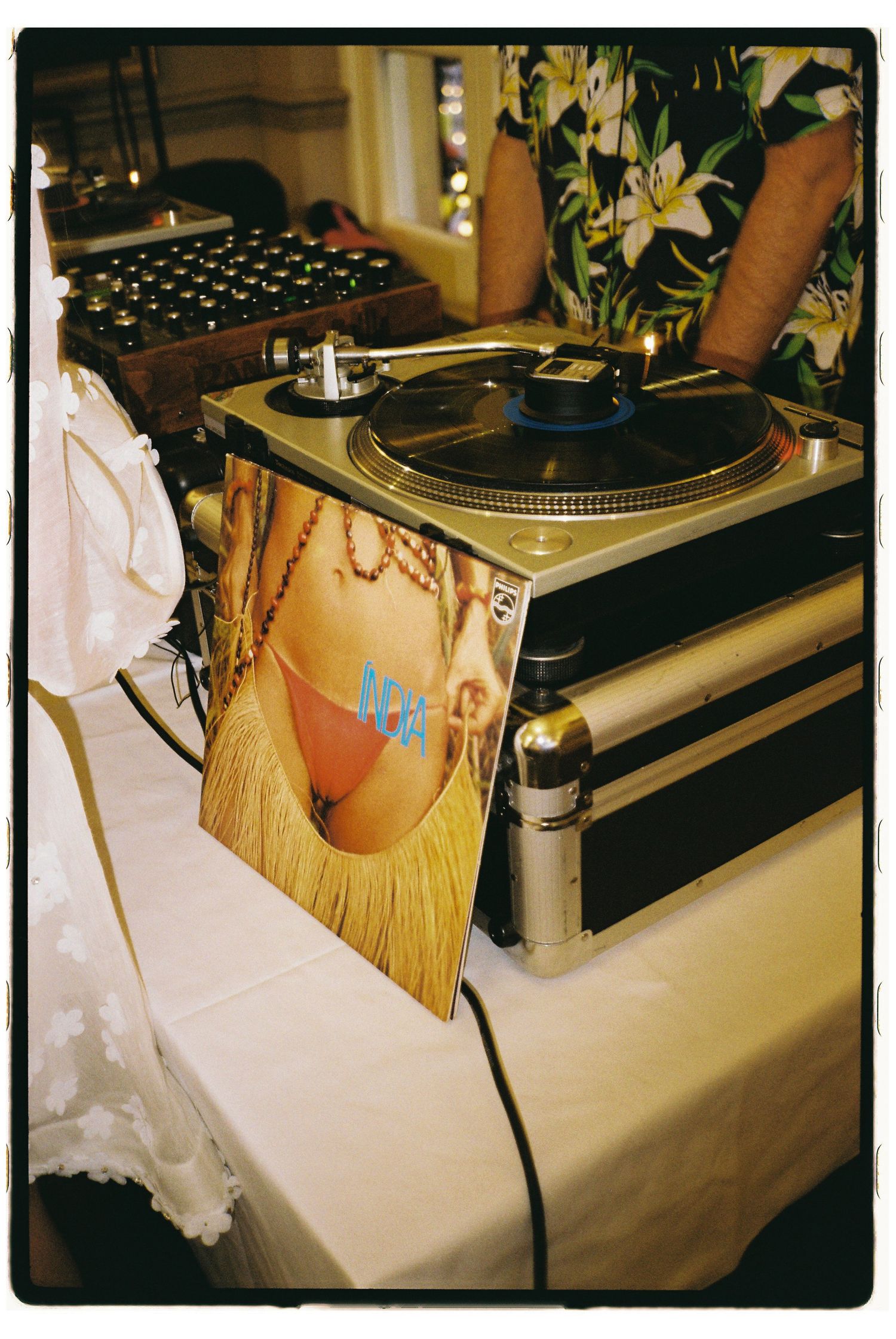 Close-up view of vintage turntables and DJ equipment set up on a white tablecloth at an event.