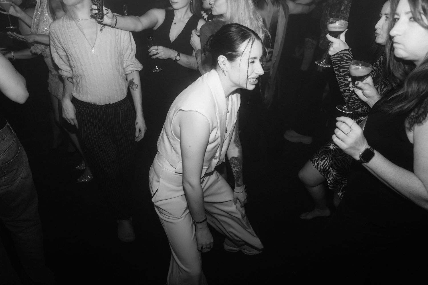 Black and white photo of people dancing at a crowded nightclub or party venue.
