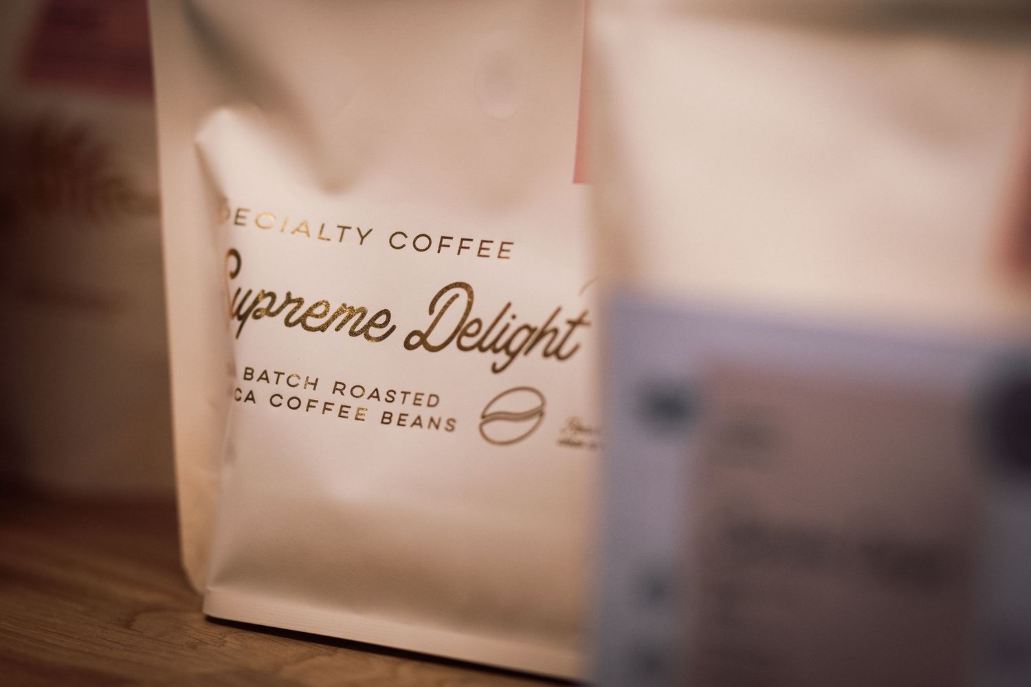 Specialty coffee bag labeled Supreme Delight small batch roasted Arabica coffee beans.