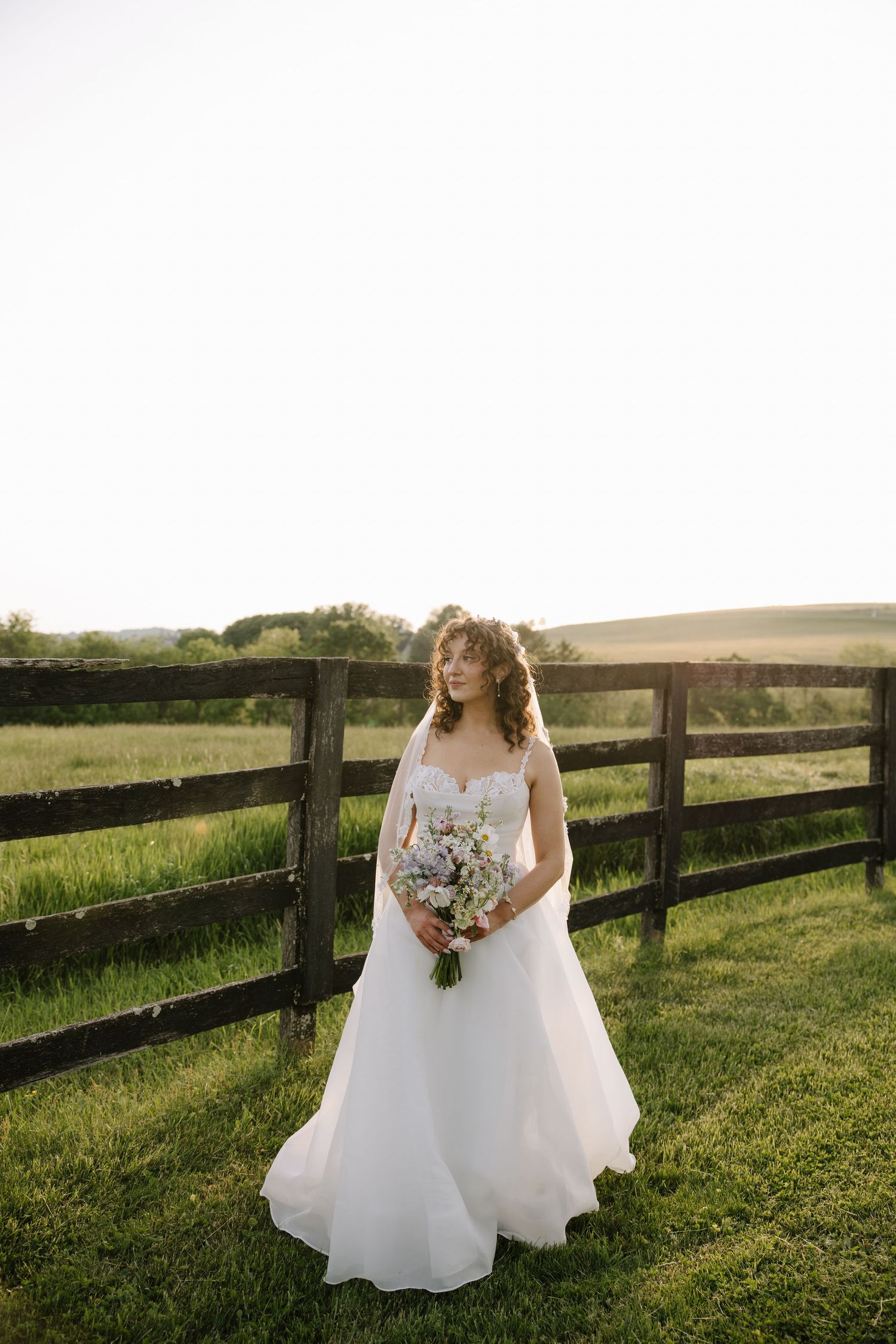 Golden hour wedding portrait of a couple overlooking the rolling hills of York County, Pennsylvania at Lauxmont Farms.