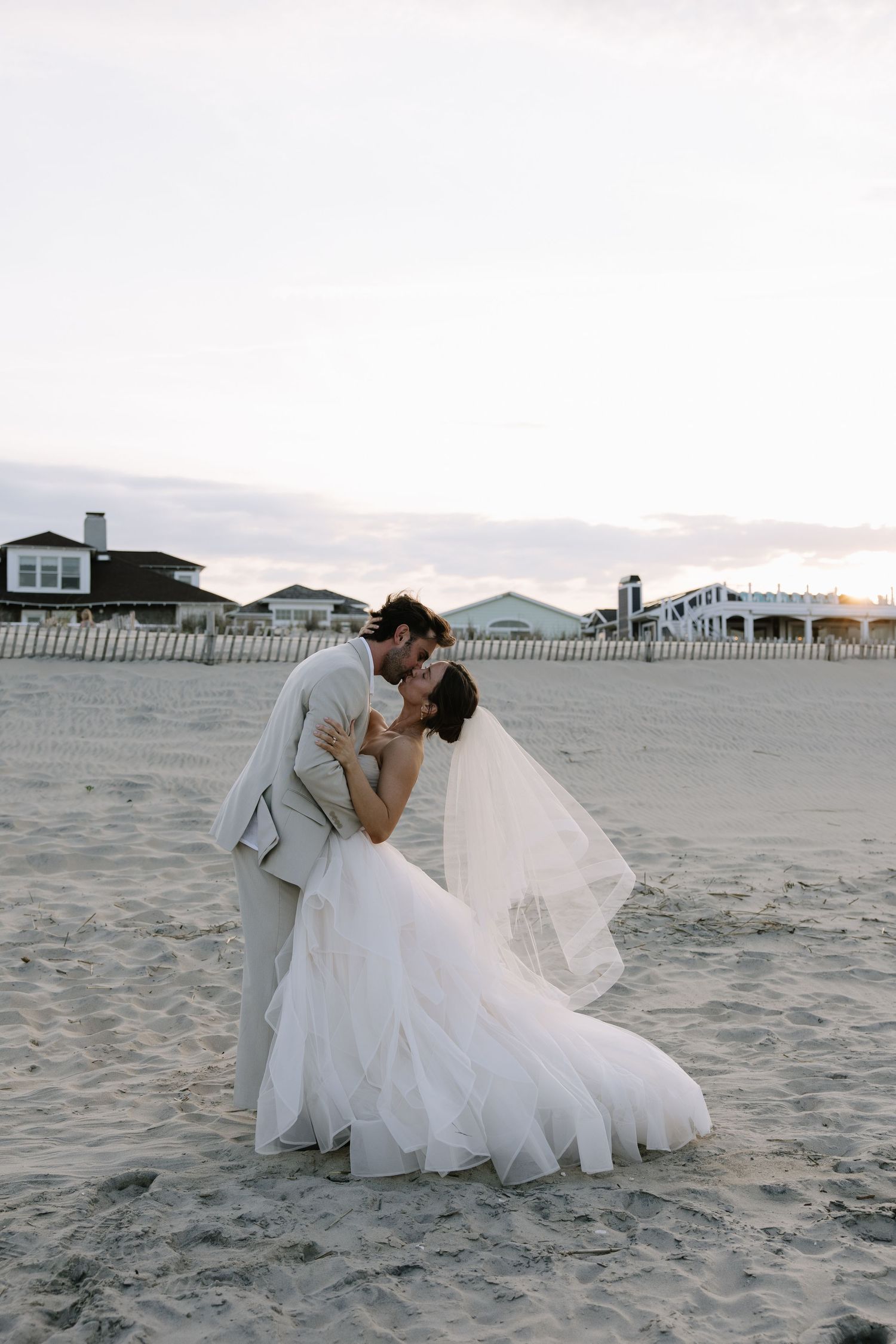 Bride and groom celebrating their Bethany Beach wedding with ocean views and golden sunset light on the Delaware coast.