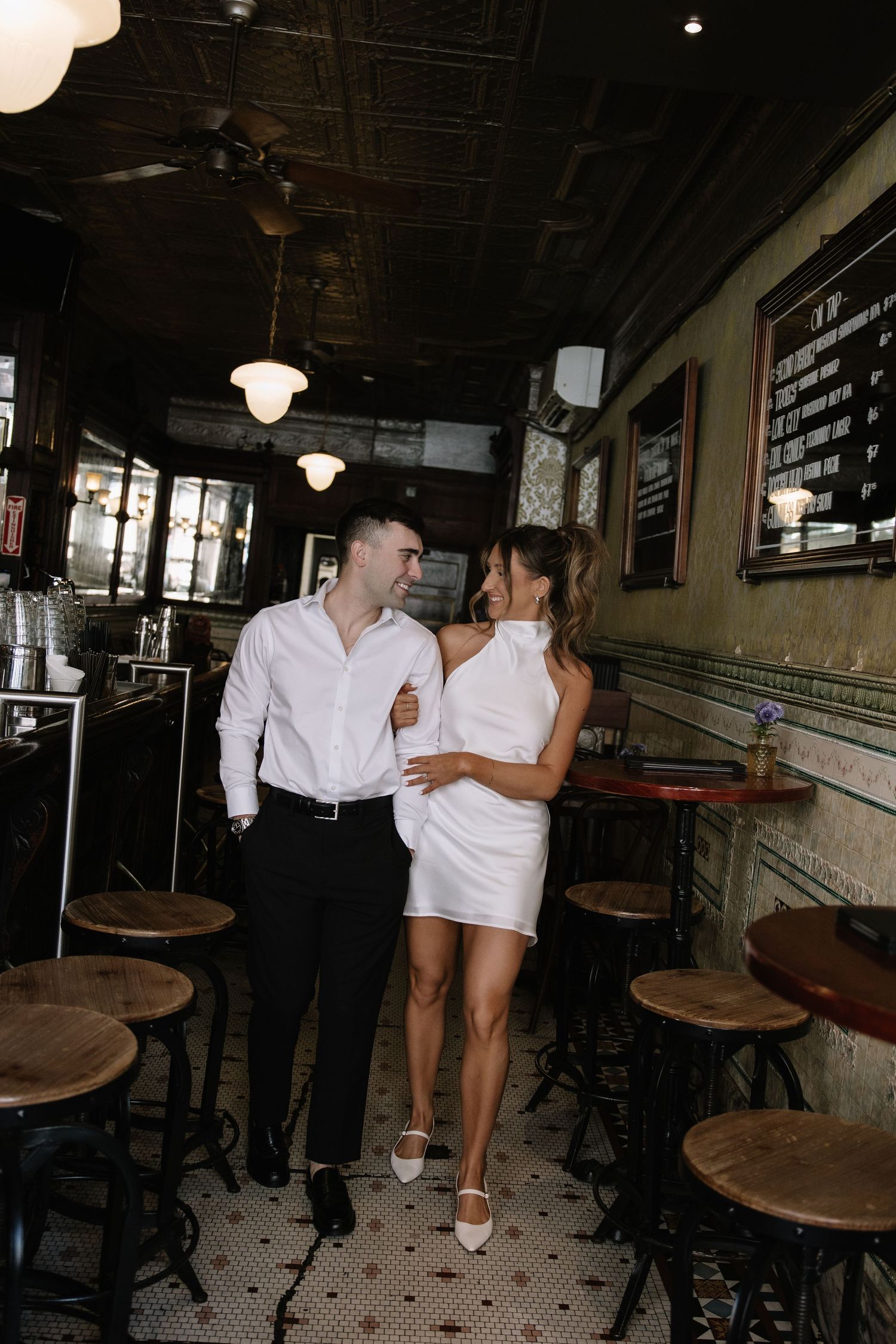 Candid spring engagement session of a couple walking along the historic cobblestone streets of Old City Philadelphia.