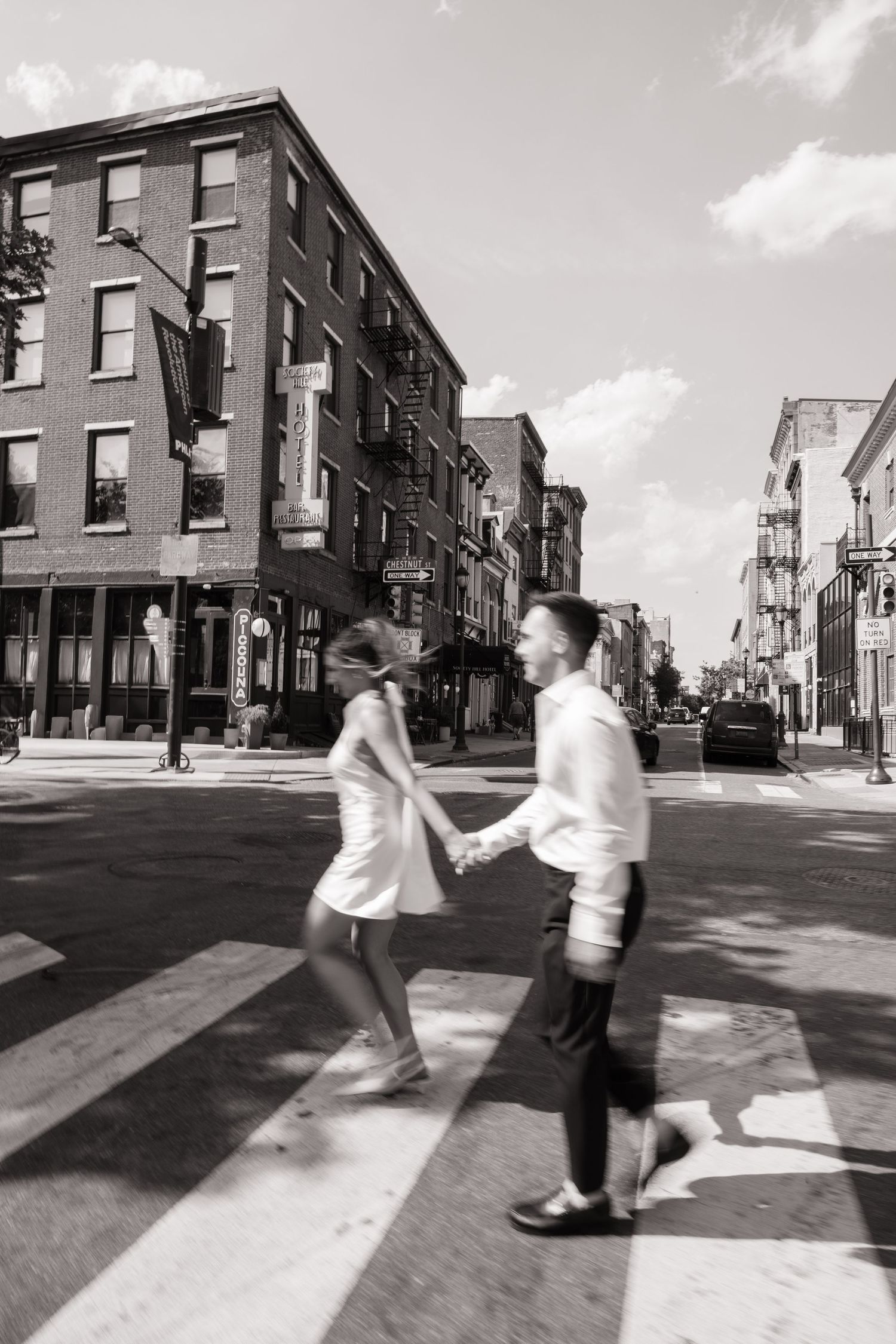 Candid spring engagement session of a couple walking along the historic cobblestone streets of Old City Philadelphia.