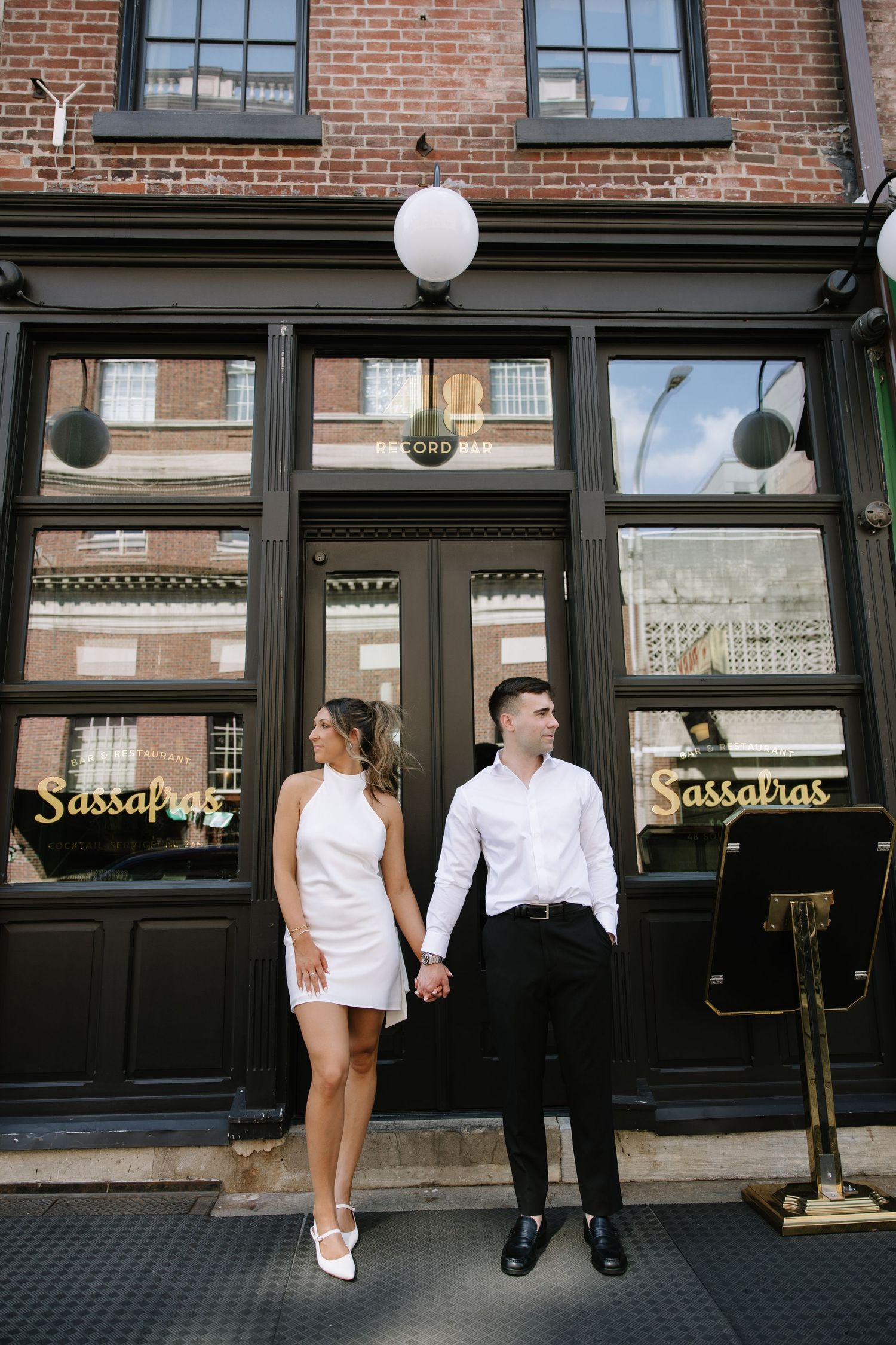 Candid spring engagement session of a couple walking along the historic cobblestone streets of Old City Philadelphia.