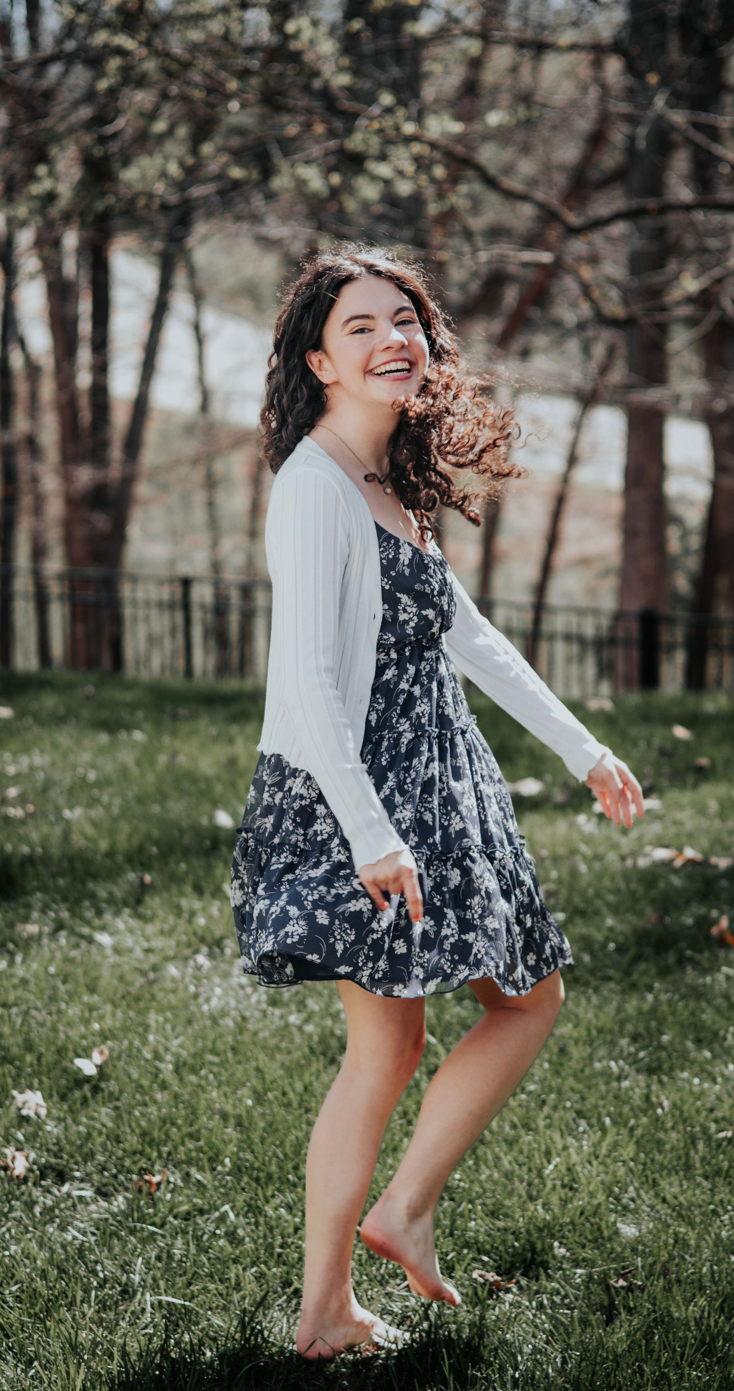Senior girl posing in front of dogwood trees in O'Fallon, MO for her senior photo session.