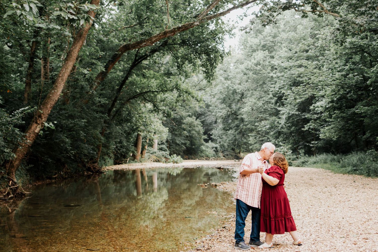 Older couple sharing a romantic moment by a creek in Troy, MO