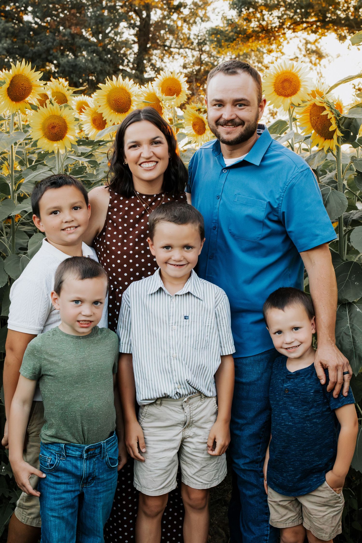 Family of 6 taking family portraits among sunflowers in Silex, MO
