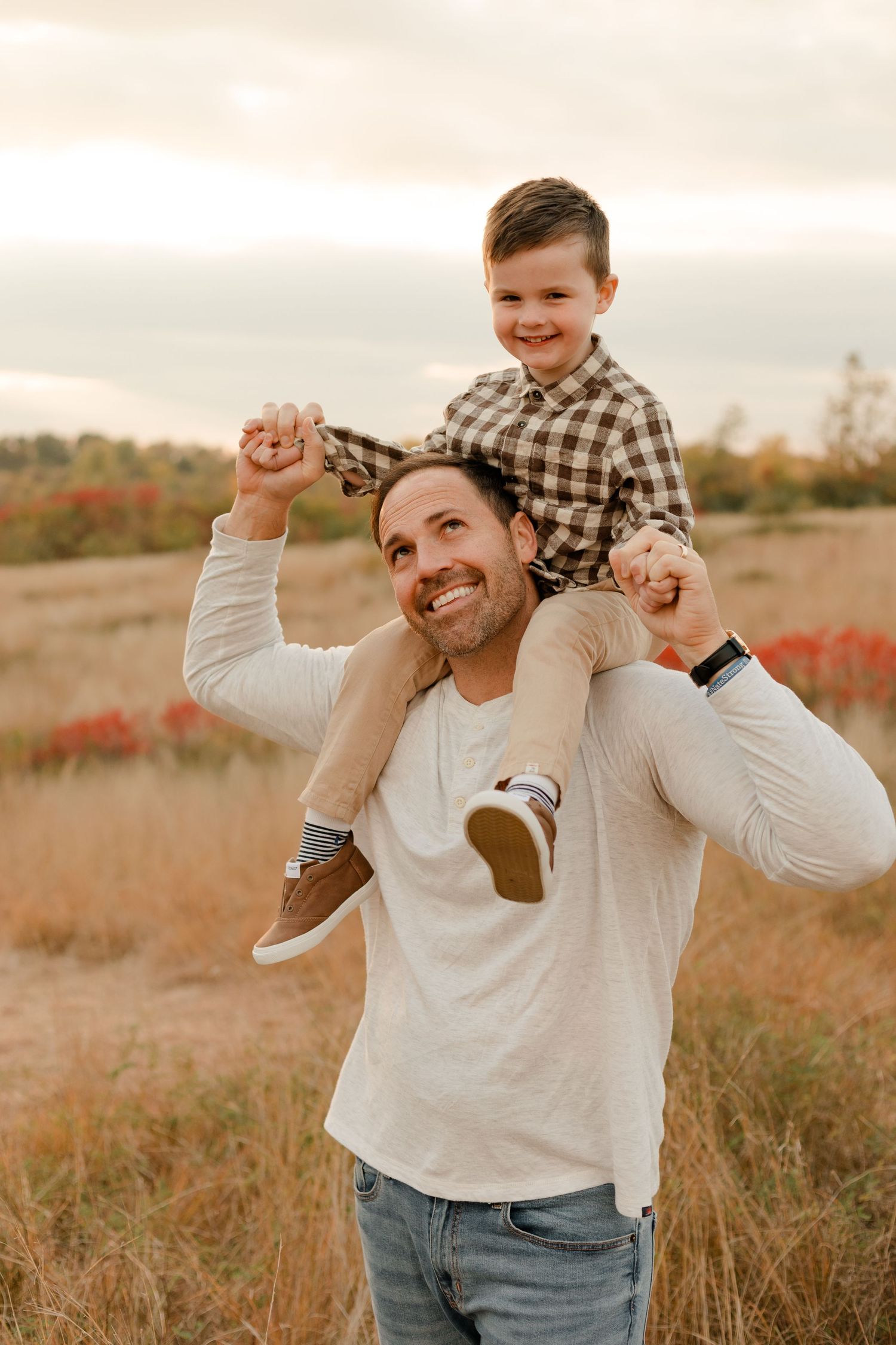 A joyful moment captured in a golden field at sunset as they share smiles and laughter together.