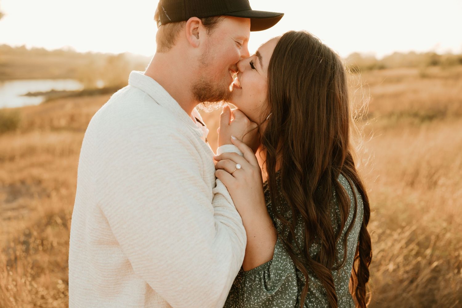 A romantic couple sharing a tender moment in a golden field at sunset.