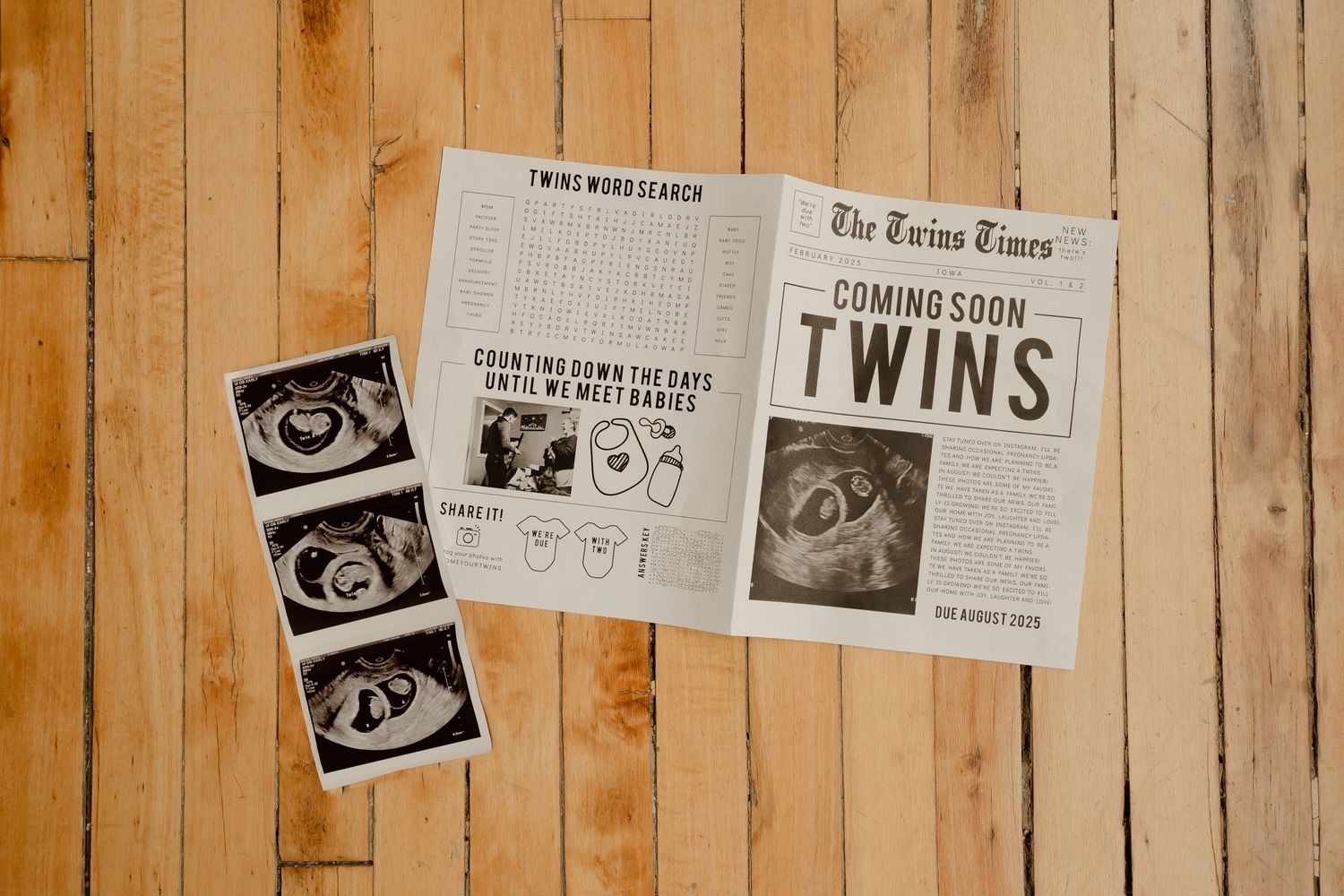 Ultrasound photos and newspaper announcement for twins laid on wooden floor boards.