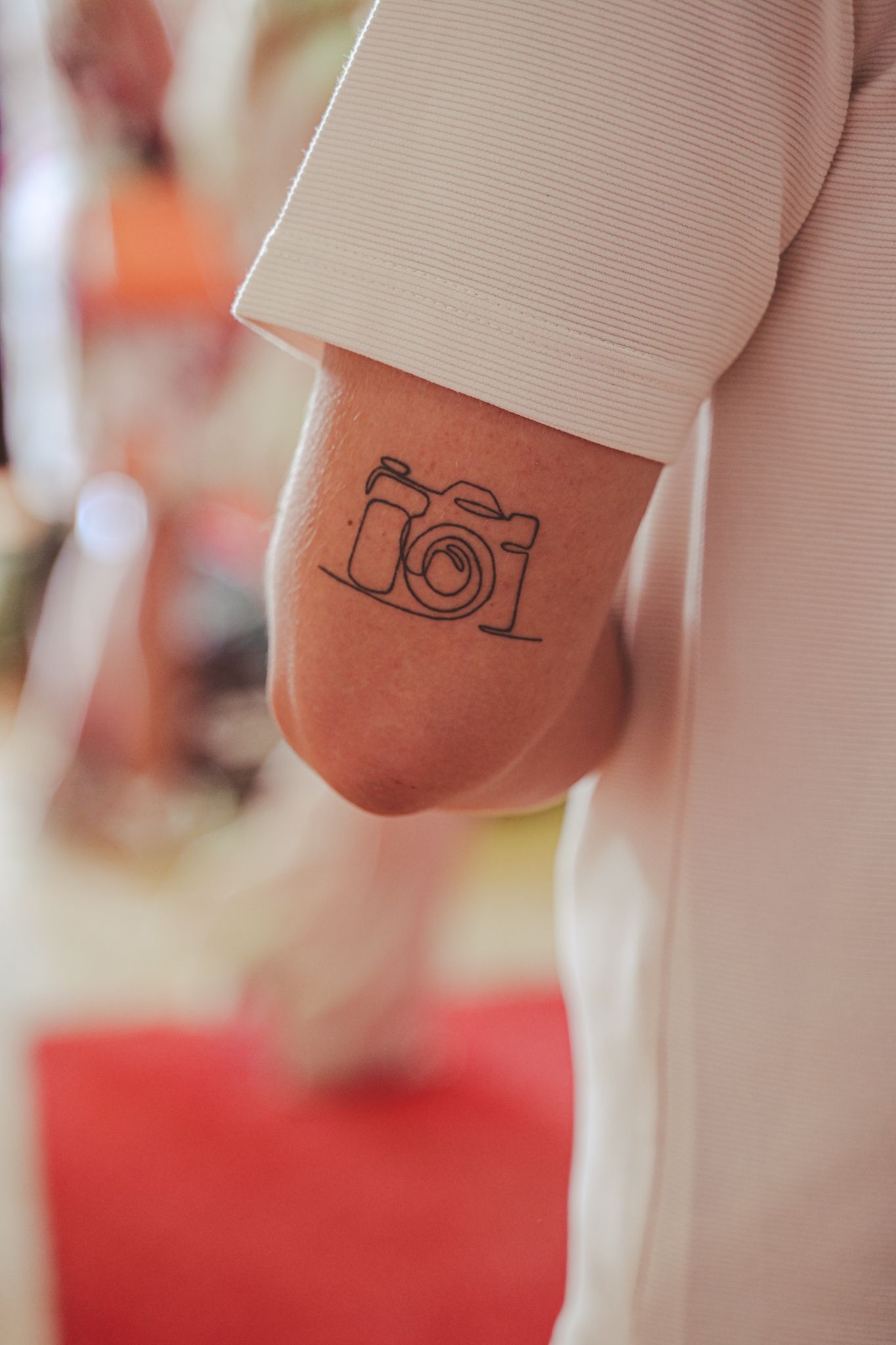 Een foto van een elleboog met een tattoe van een camera