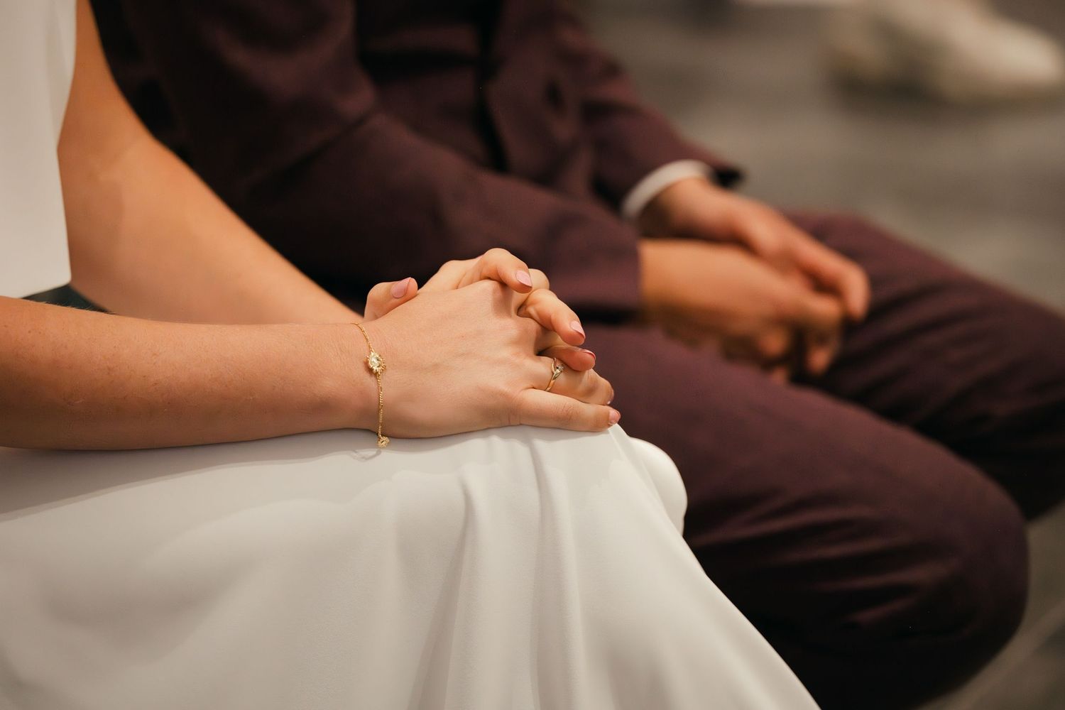 Kleurenfoto van een man en een vrouw in de kerk, met de handen gevouwen. Trouwfotografie