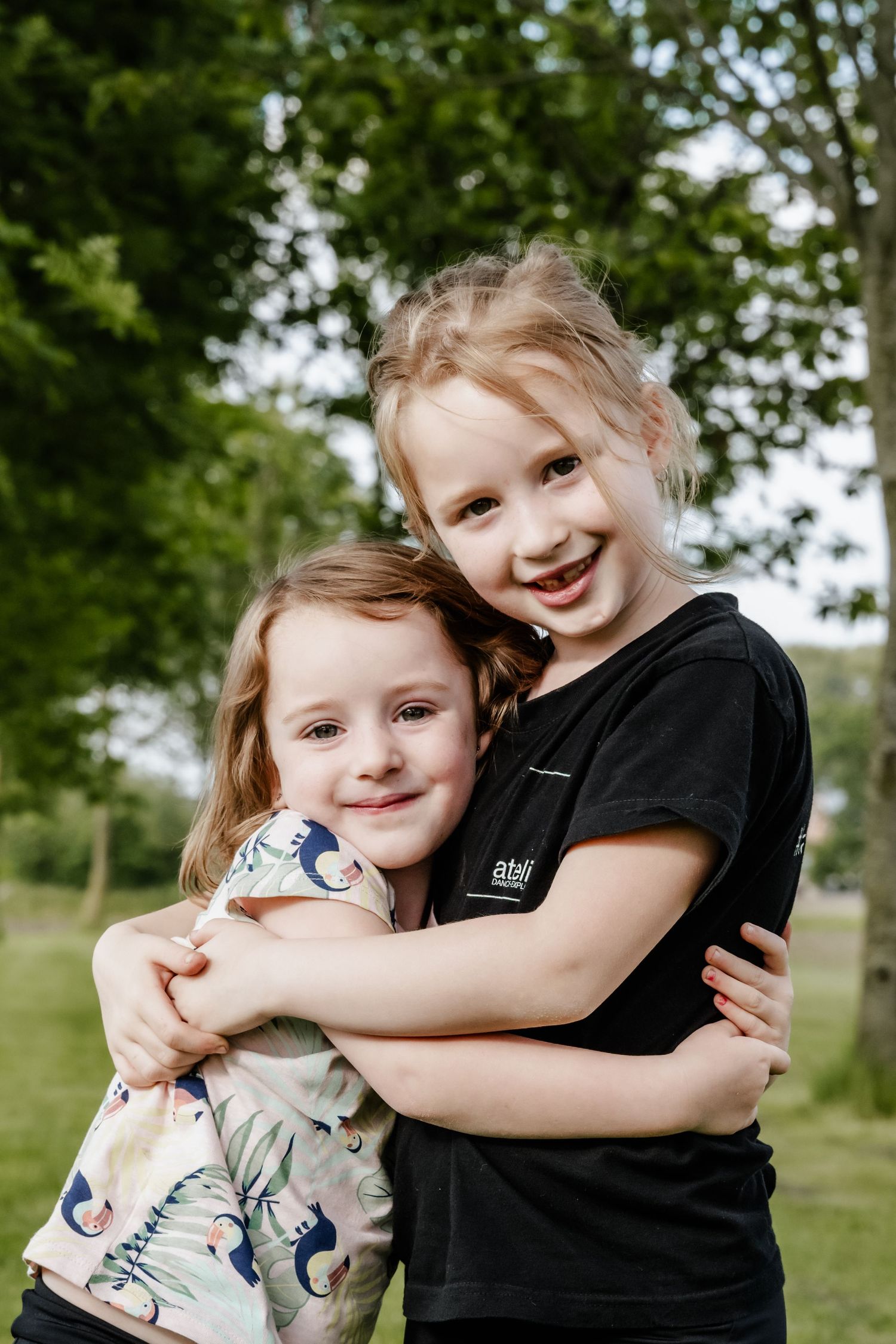 Twee knuffelende zusjes in natuuromgeving