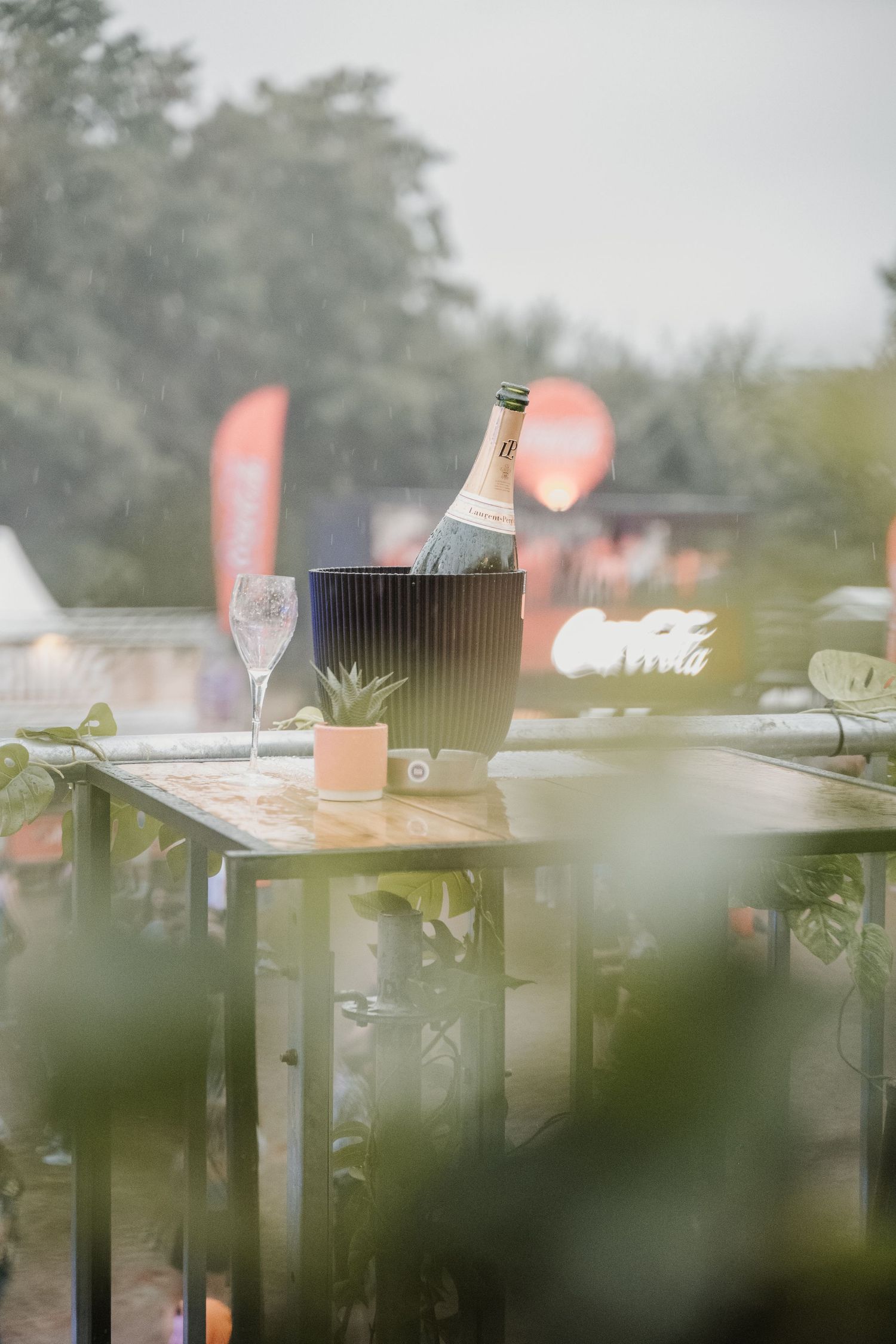Een doorkijkje van een lege fles cava in een ijsemmer op een dance festival