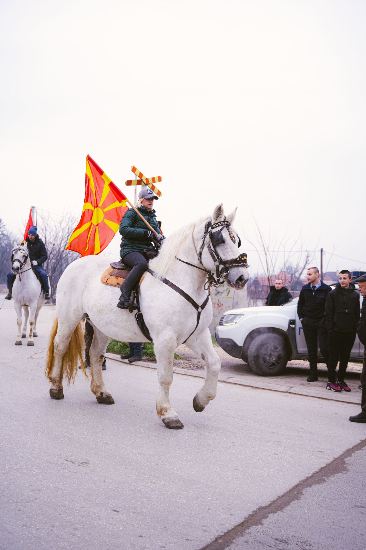 Een man met een vlag op een wit groot paard
