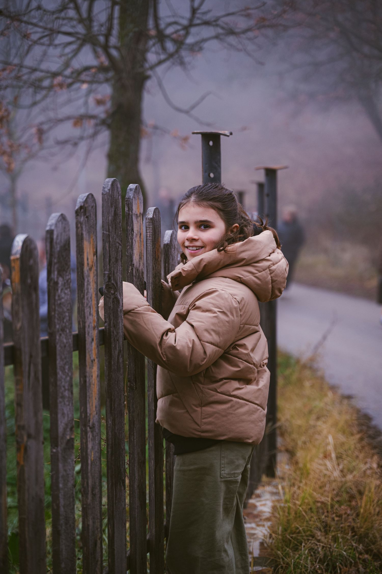 Kleurfoto van een meisje in een natuurlandschap dat lacht naar de camera