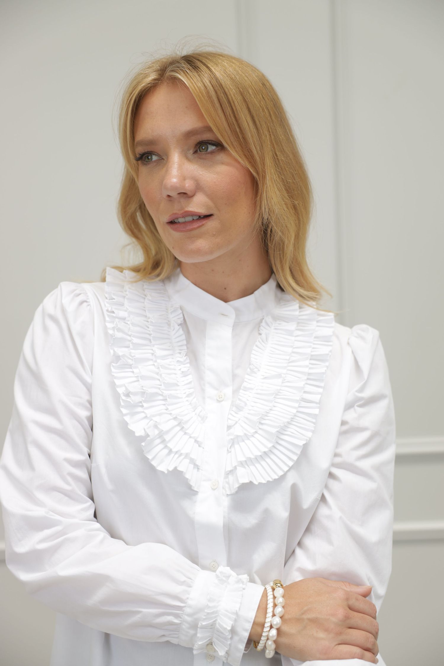 Blonde woman in white blouse, studio portrait
