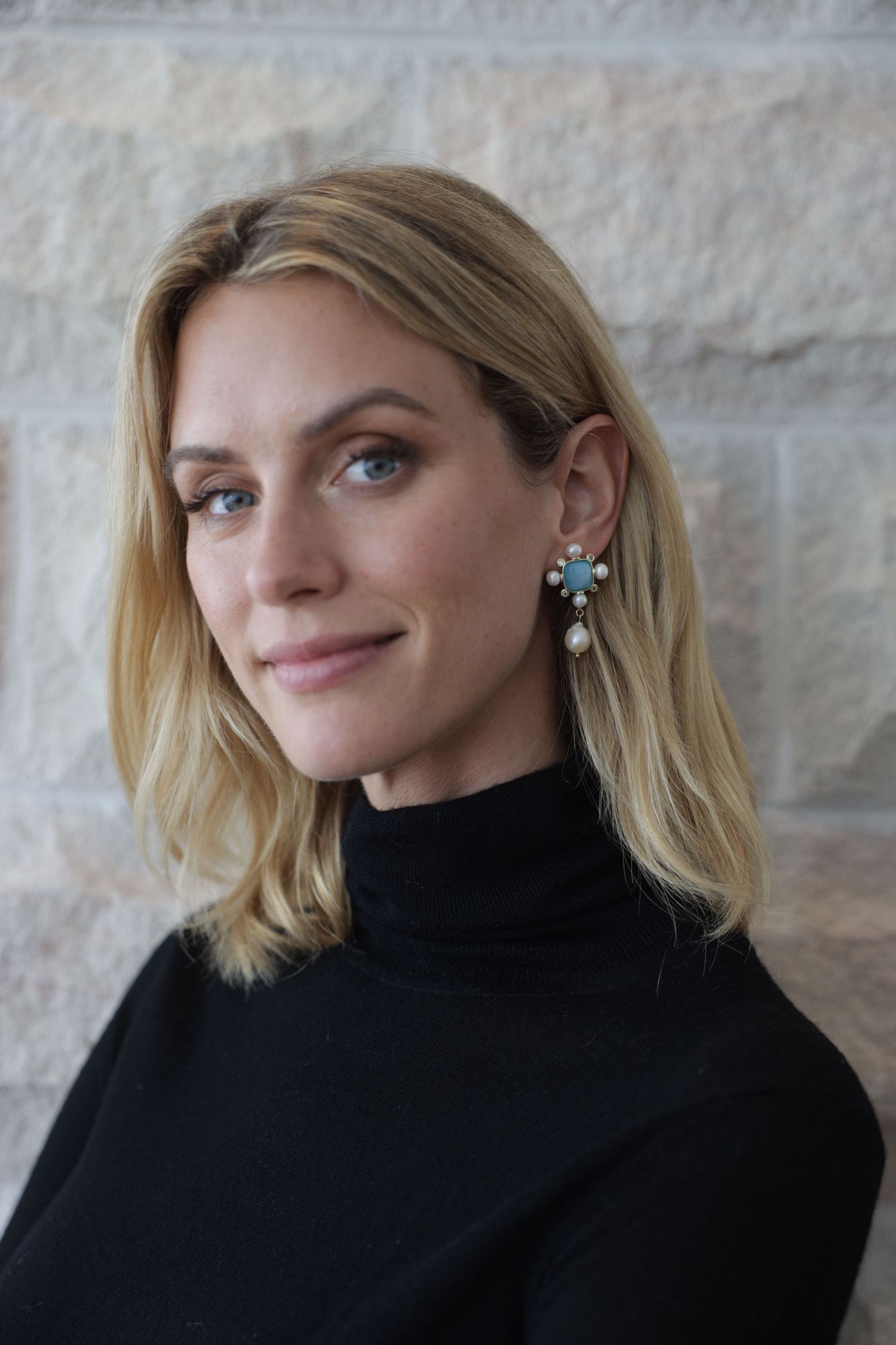 Blonde woman in black turtleneck, studio portrait