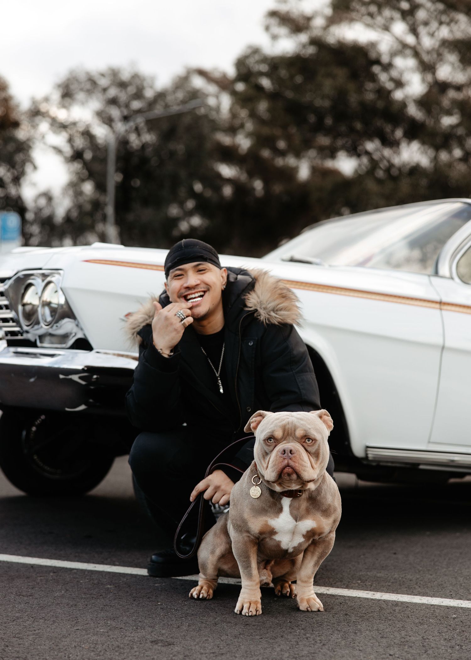 Man with dog and classic car at sunset, outdoor lifestyle moment.