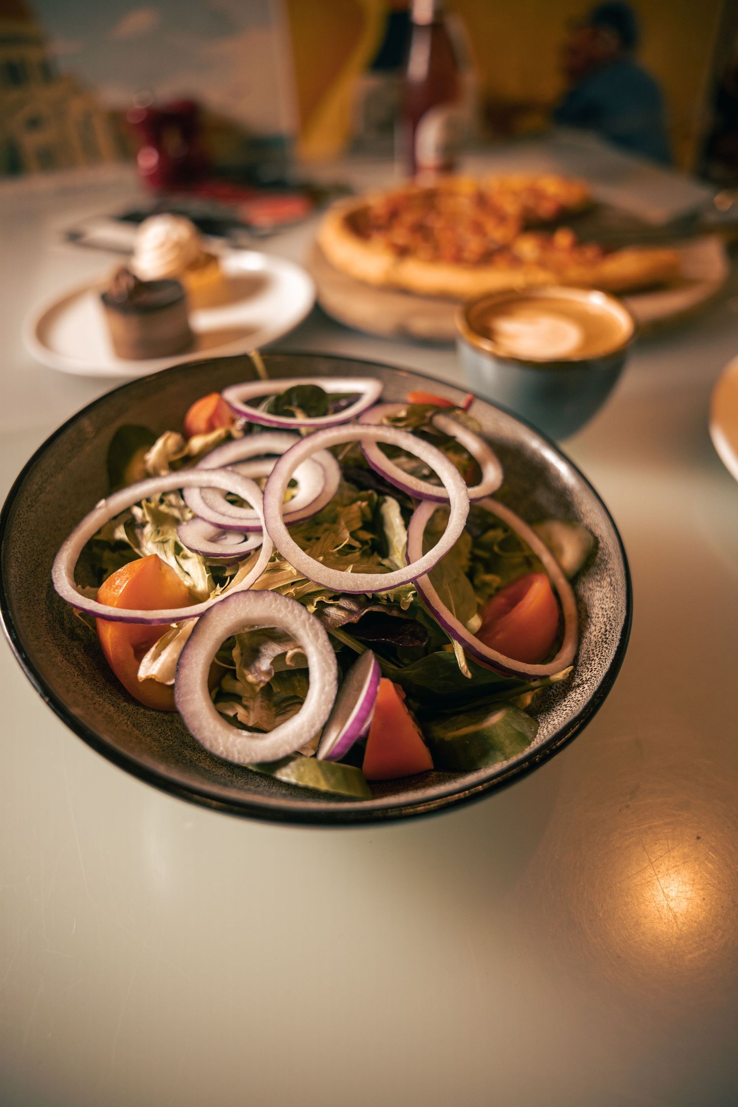Bowl of pasta with herbs and sauce, styled food photography overhead.