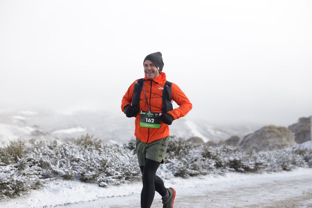 Two trail runners hiking rugged mountain path during race.