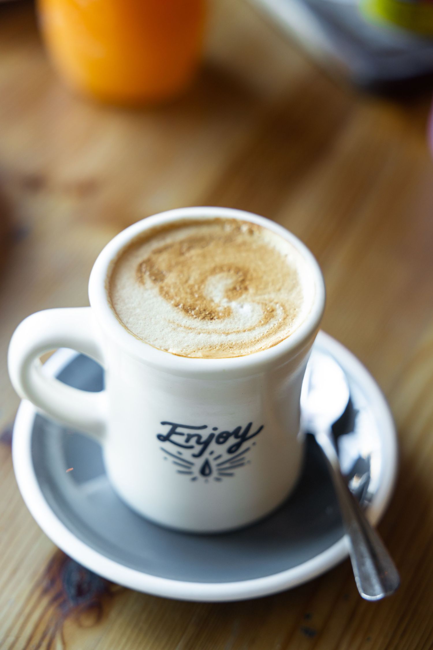 Cup of cappuccino with frothy latte art on café table.