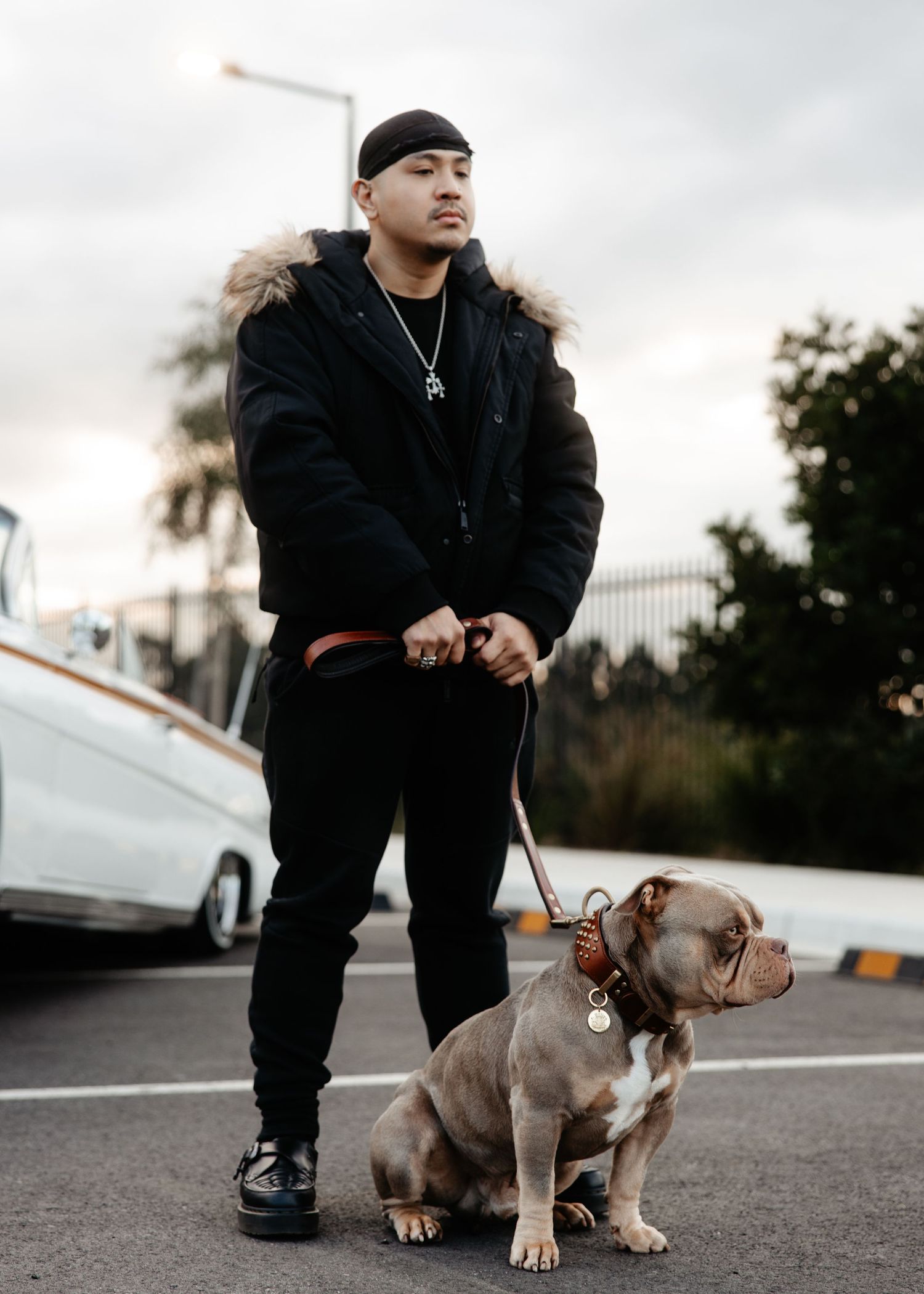 Man walking dog on road at sunset, casual lifestyle portrait.