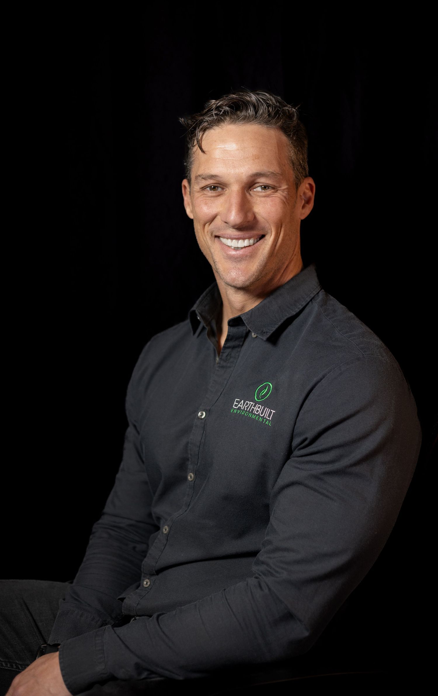 Male studio headshot with dark shirt, clean professional portrait style.