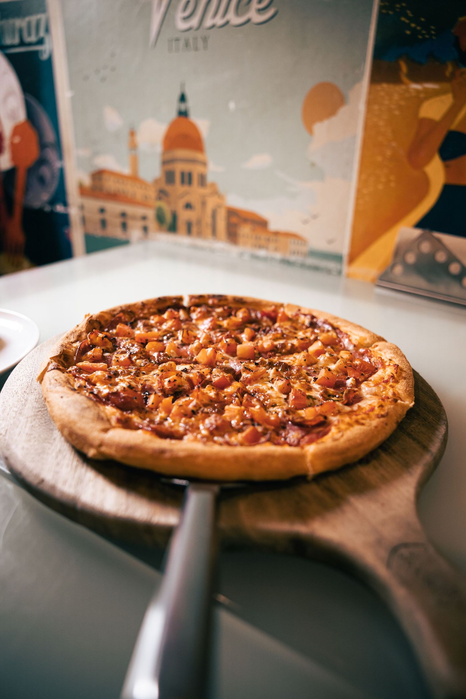 Freshly baked pizza served in pan on dining table, food detail shot.