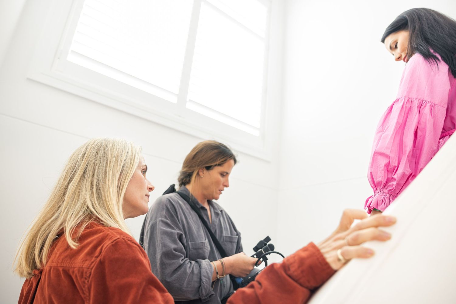Film crew directing lifestyle scene indoors with natural light.