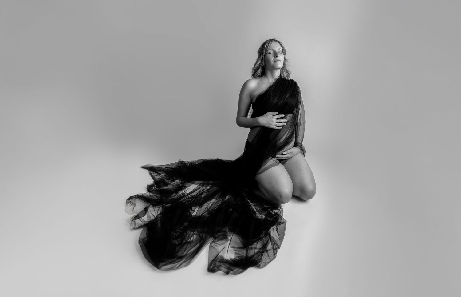 A black and white photo series showing a figure in flowing fabric creating dramatic movement and dance-like poses.