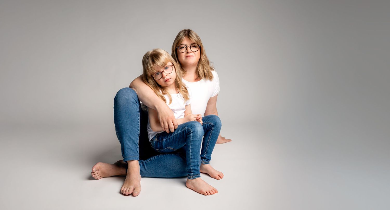 A romantic couple in denim clothing shares intimate moments in a minimalist studio setting.