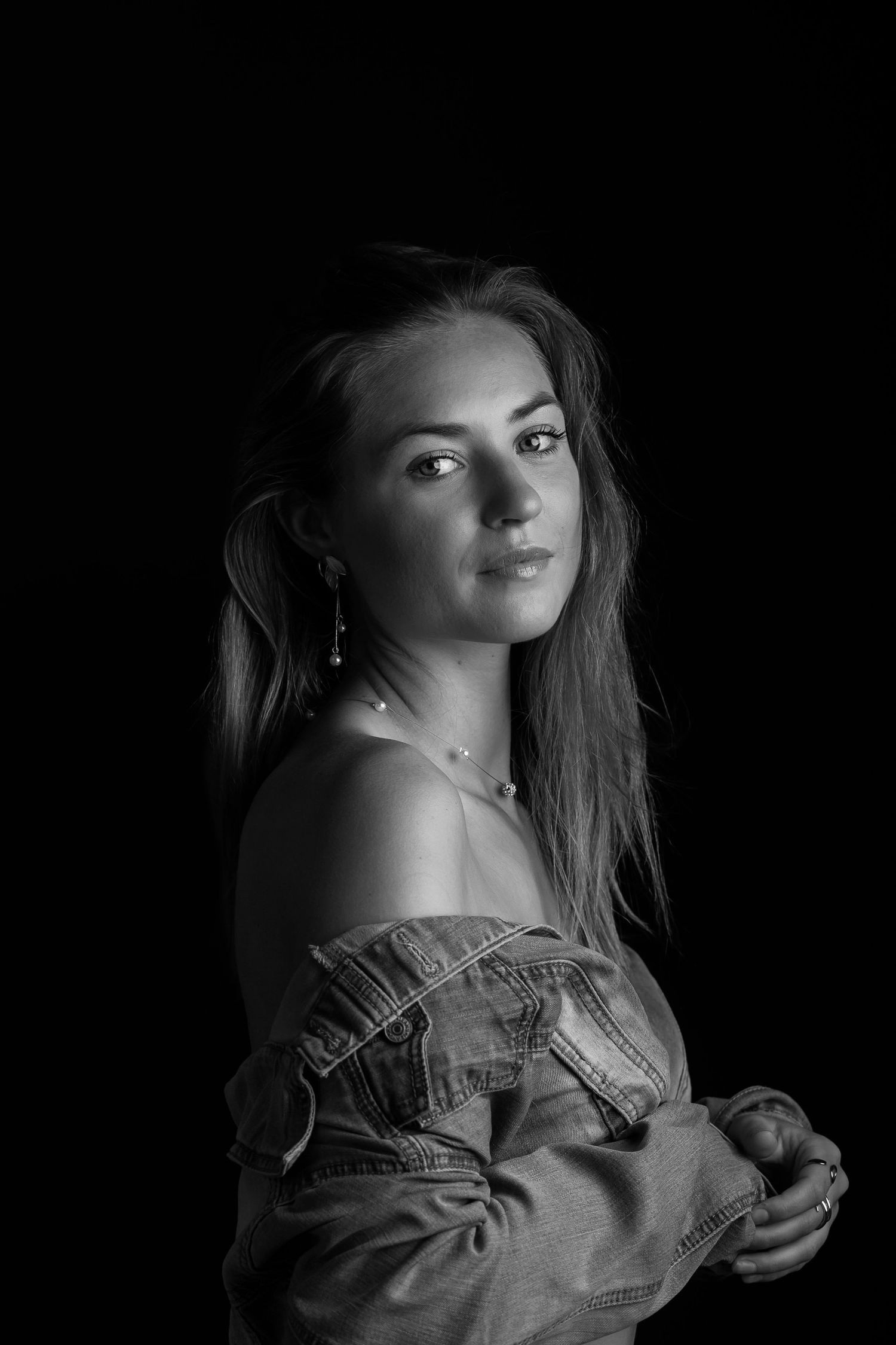 Four dramatic black and white artistic portraits showing a figure in soft lighting wearing a ruffle-detailed garment.