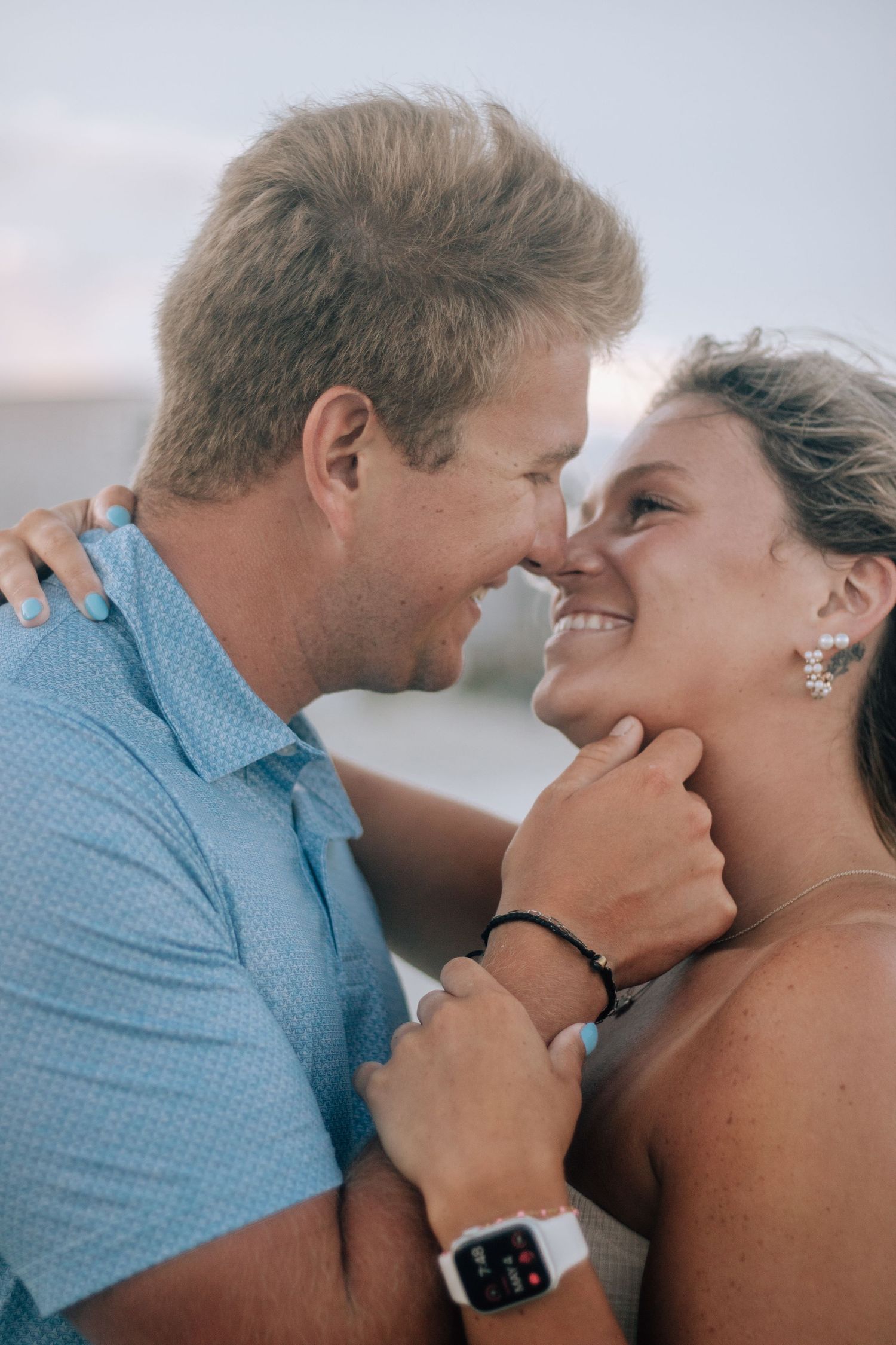 An intimate close-up moment between a couple on the beach during golden hour.
