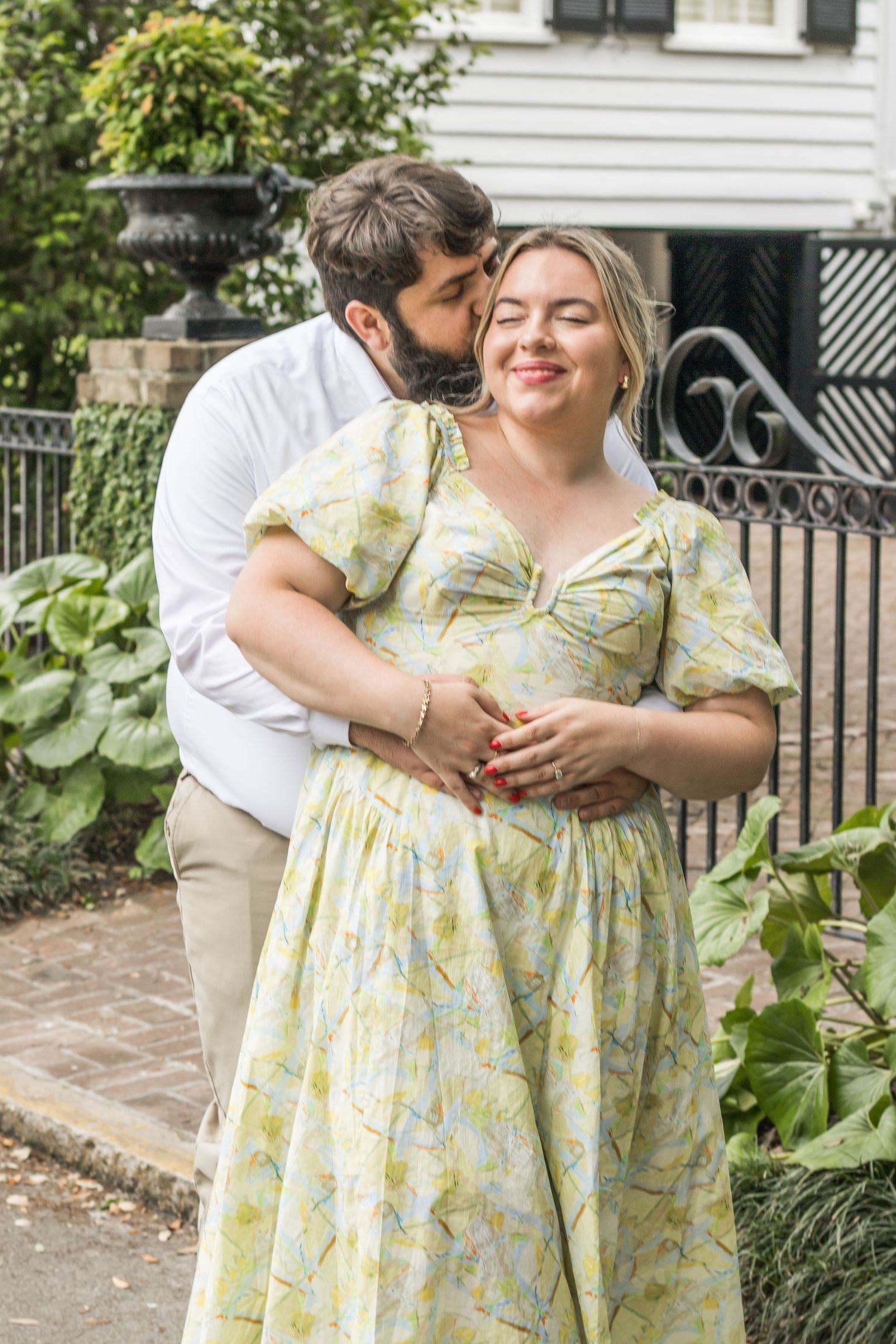 A loving couple embraces in a garden setting wearing spring attire.