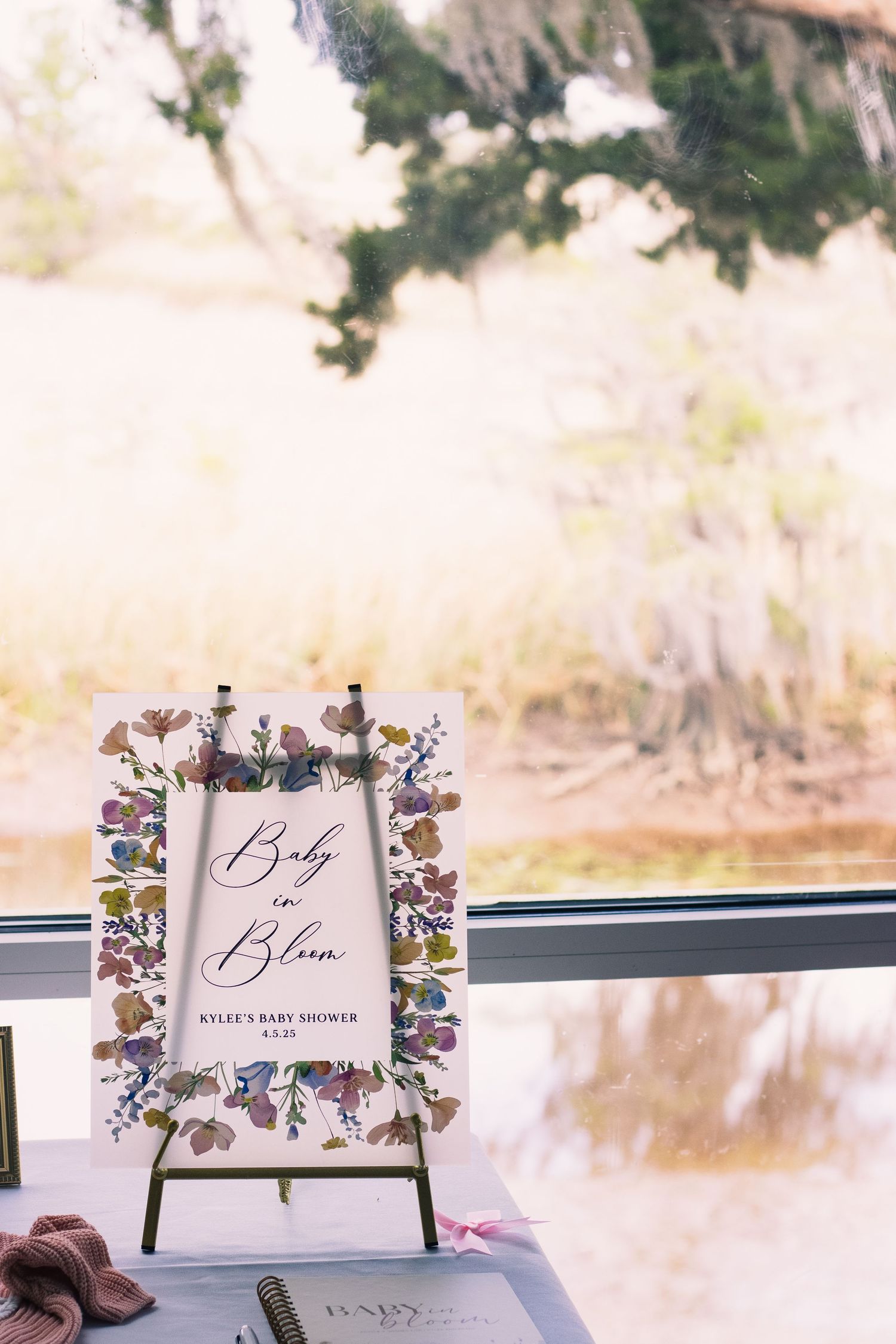 Wedding reception signage with elegant floral designs and calligraphy displayed on wooden stands.