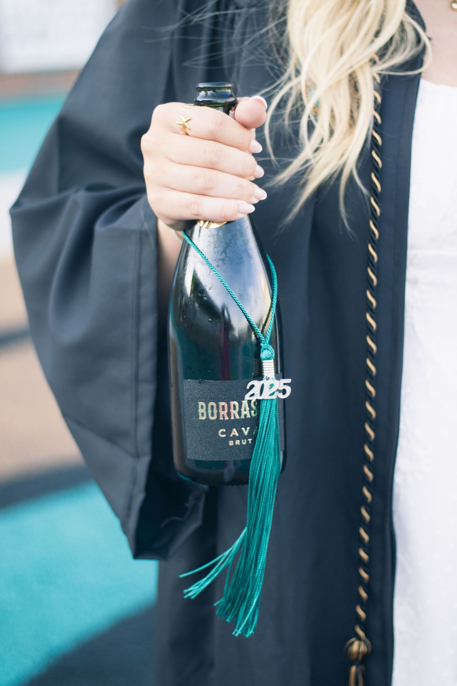 Close-up details of graduation cap tassel and commemorative charm.