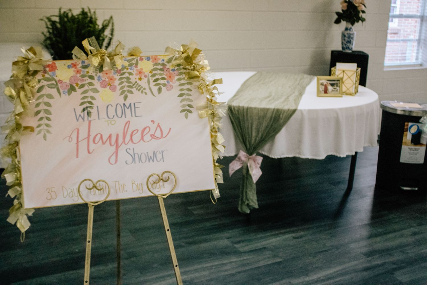 Decorative wedding reception signs with gold stands arranged in an indoor venue.