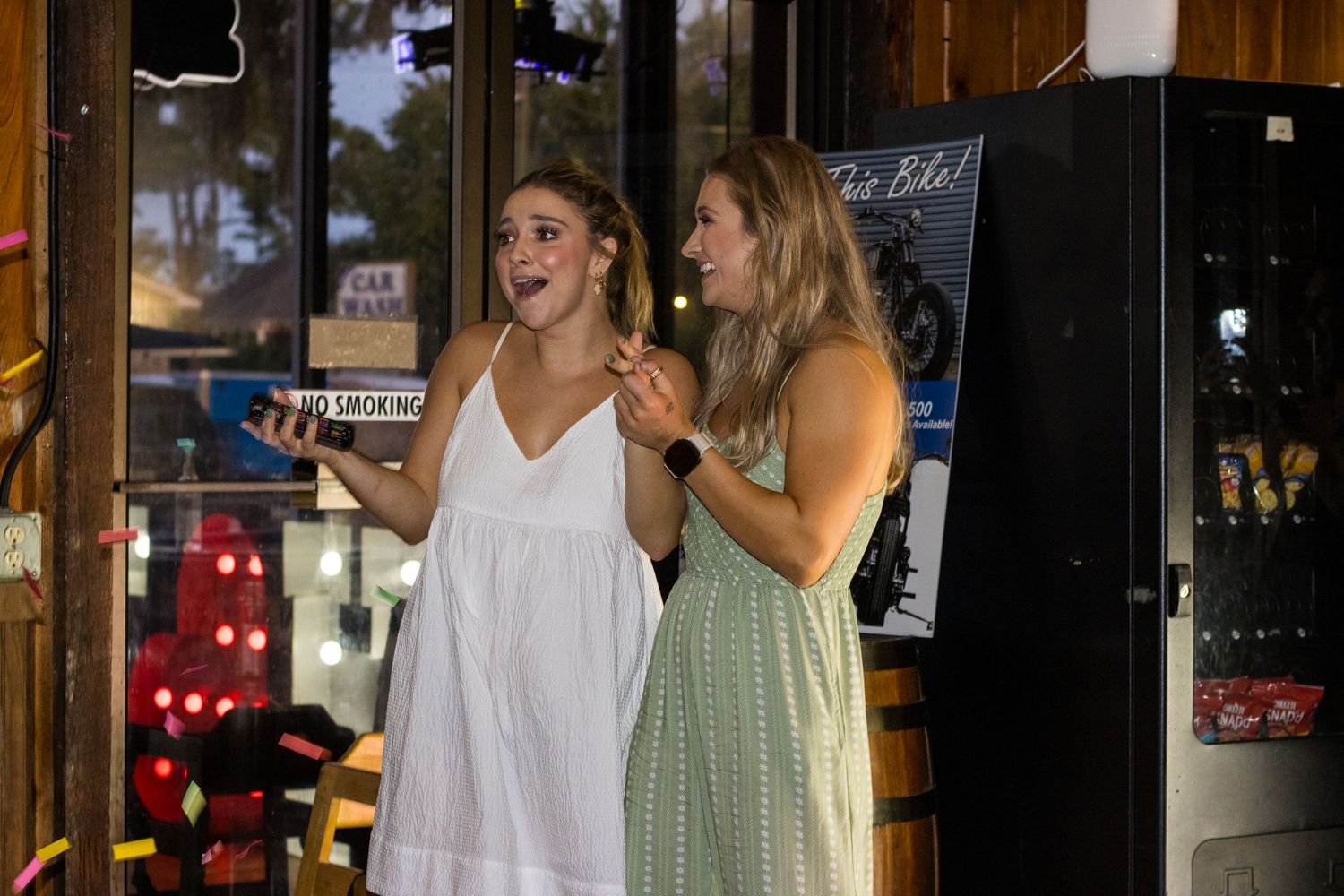 Patrons enjoy drinks and conversation at a dimly lit bar decorated with string lights and wooden accents.