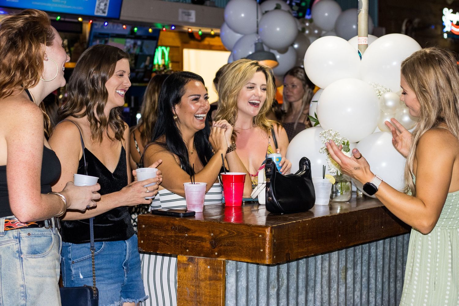 A group of people gather and socialize at a lively bar or restaurant setting.