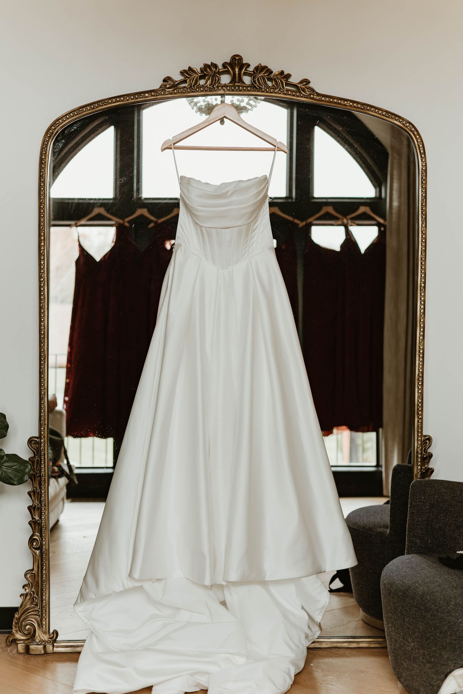 A white strapless wedding dress is displayed against a mirrored backdrop in multiple reflective angles.