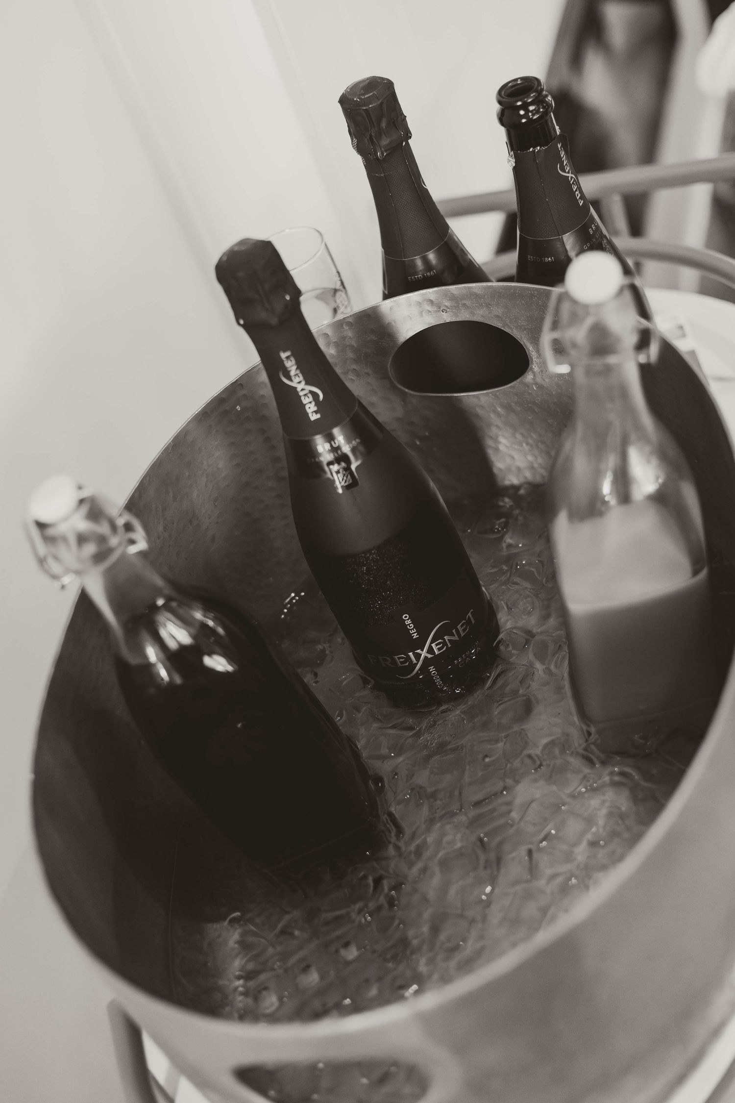 Wine bottles chilling in an ice bucket at an elegant event.