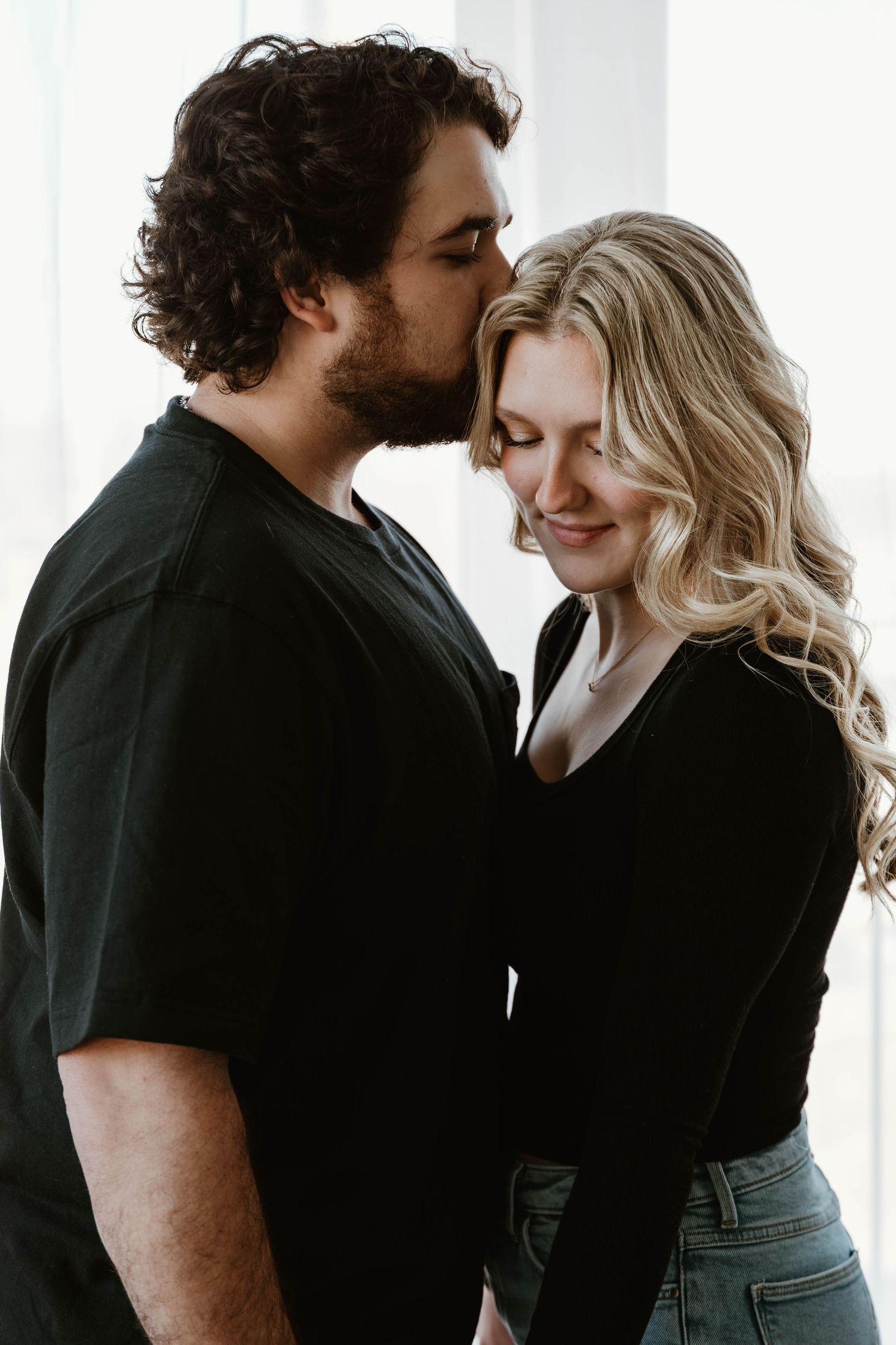 Intimate couple portraits showing tender moments against a bright white studio backdrop.