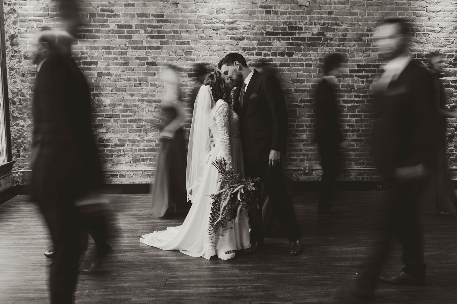 A series of black and white photographs showing couples sitting and leaning against a brick wall.
